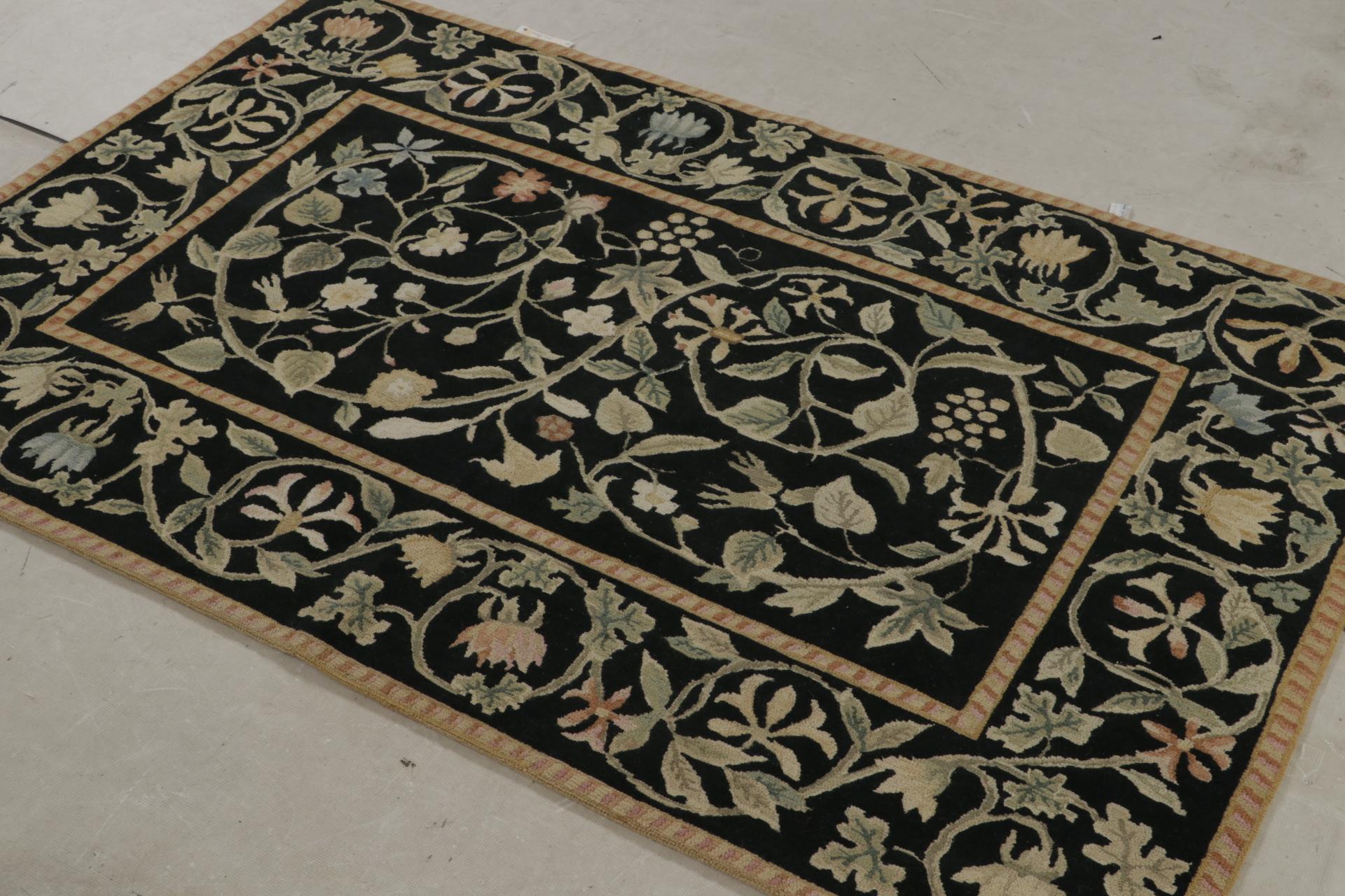 Dieser handgeknüpfte Wollteppich 4x6 in Schwarz ist die erste Iteration dieses Designs in Hoch-Tief-Struktur. Mit seinen beige-braunen, grünen und rosafarbenen Blumenmustern und vielen anderen helleren Tönen ist dieser Teppich von Tudor-Designs