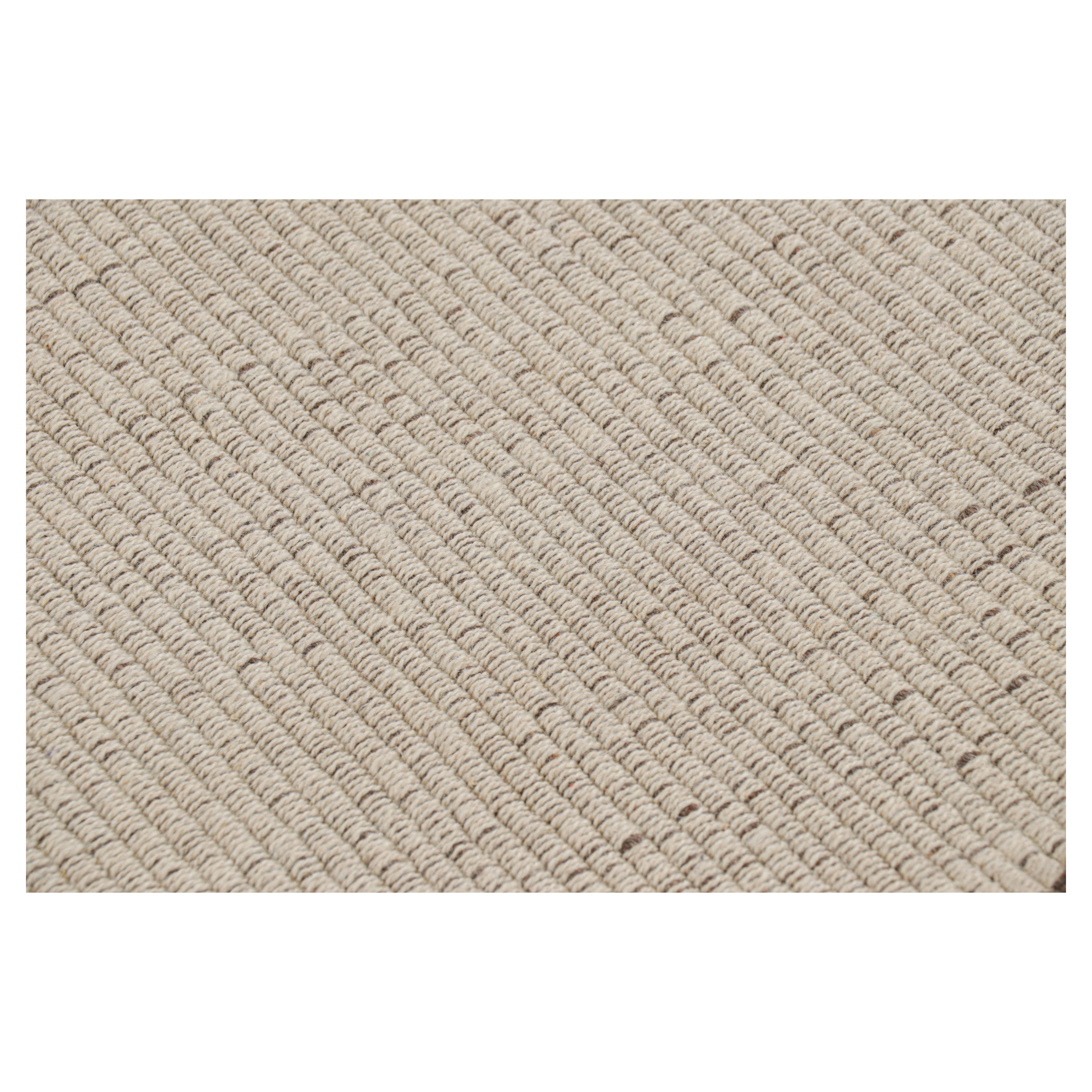 Un modello Kilim 2x19 della nostra selezione di trame piatte moderne e più resistenti, tessuto a mano in lana e proveniente dall'India, presenta accenti beige e marrone cioccolato e un sottotono bianco crema nell'ordito e nella trama.

Sul design: