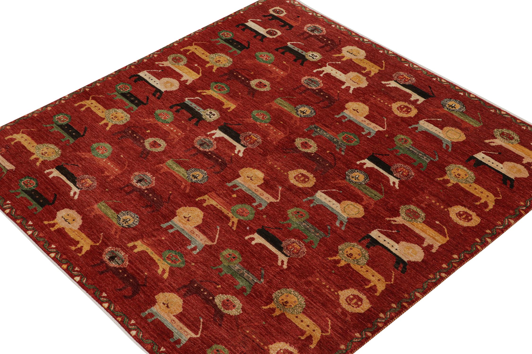 Ein 10x10 Teppich nach Maß, inspiriert von antiken persischen Gabbeh-Teppichen - aus der Modern Classics Collection'S von Rug & Kilim. Es ist aus Wolle handgeknüpft und zeigt eine verspielte Symphonie leuchtender und reicher Löwenmotive auf rotem