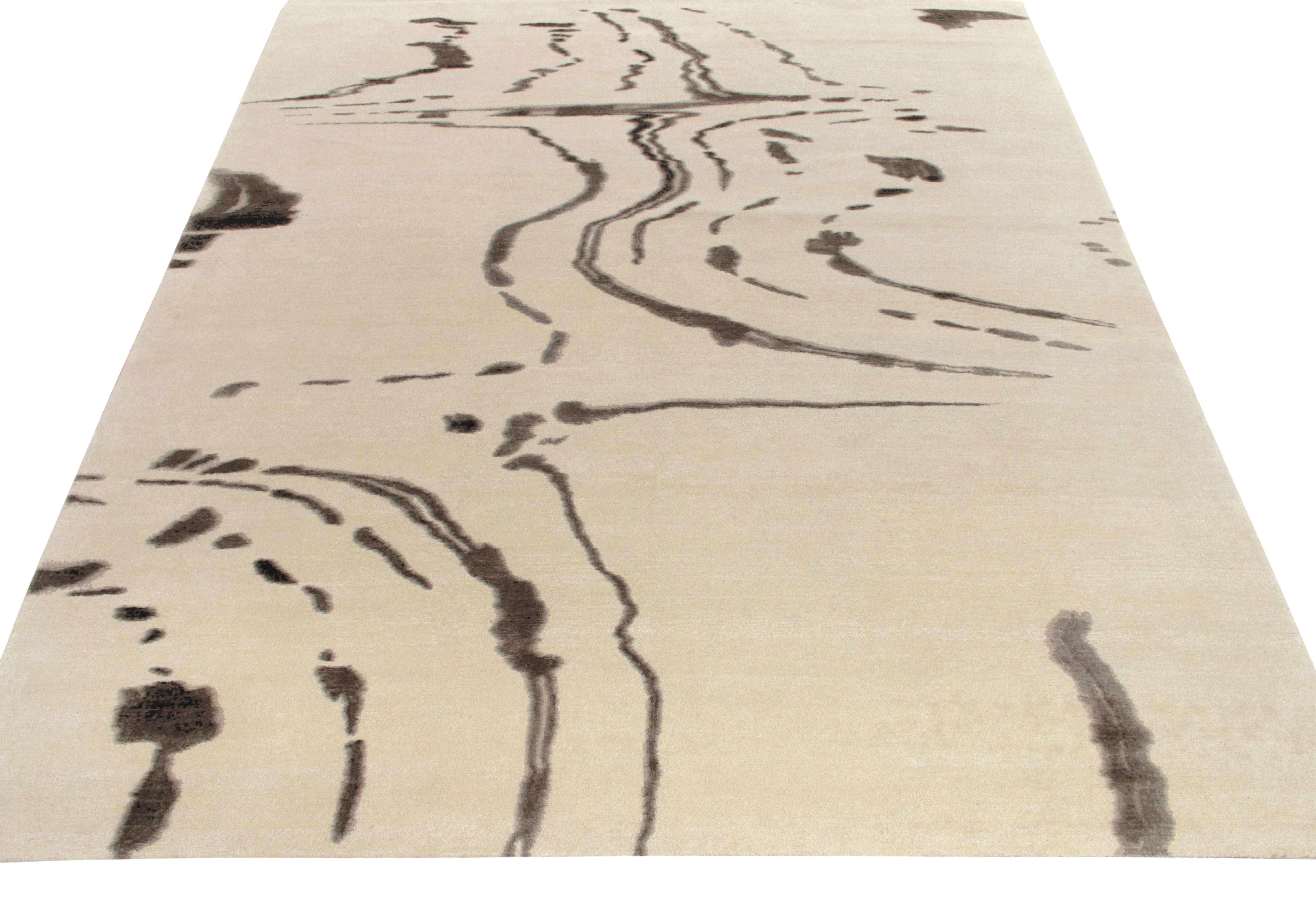 An 8 x 10 modern rug from the abstract styles in Rug & Kilim’s New & Modern Collection. Hand-knotted in wool, this quiet piece expresses itself in tones of beige and rich brown with positive-negative plays of white and black for an added sense of