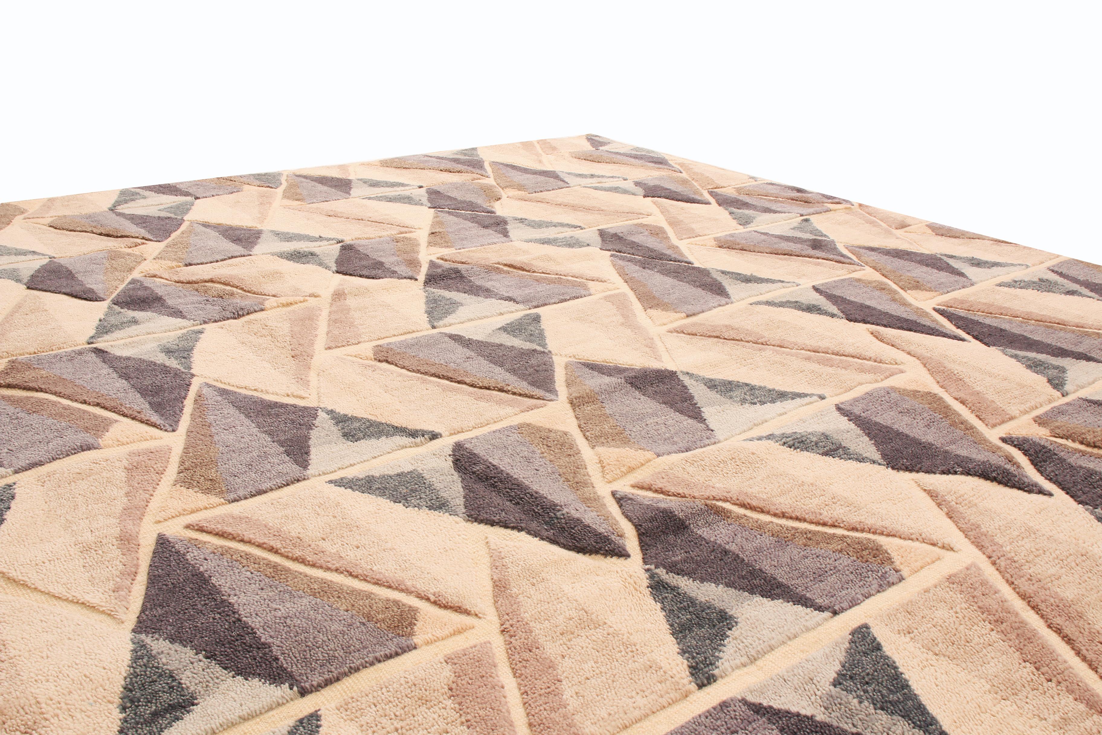 Originario dell'India, questo tappeto geometrico è annodato a mano in lana di alta qualità con un disegno a campo libero che unisce influenze di motivi prismatici e sensibilità cromatiche del Mid-Century Modern. Il disegno geometrico perfettamente