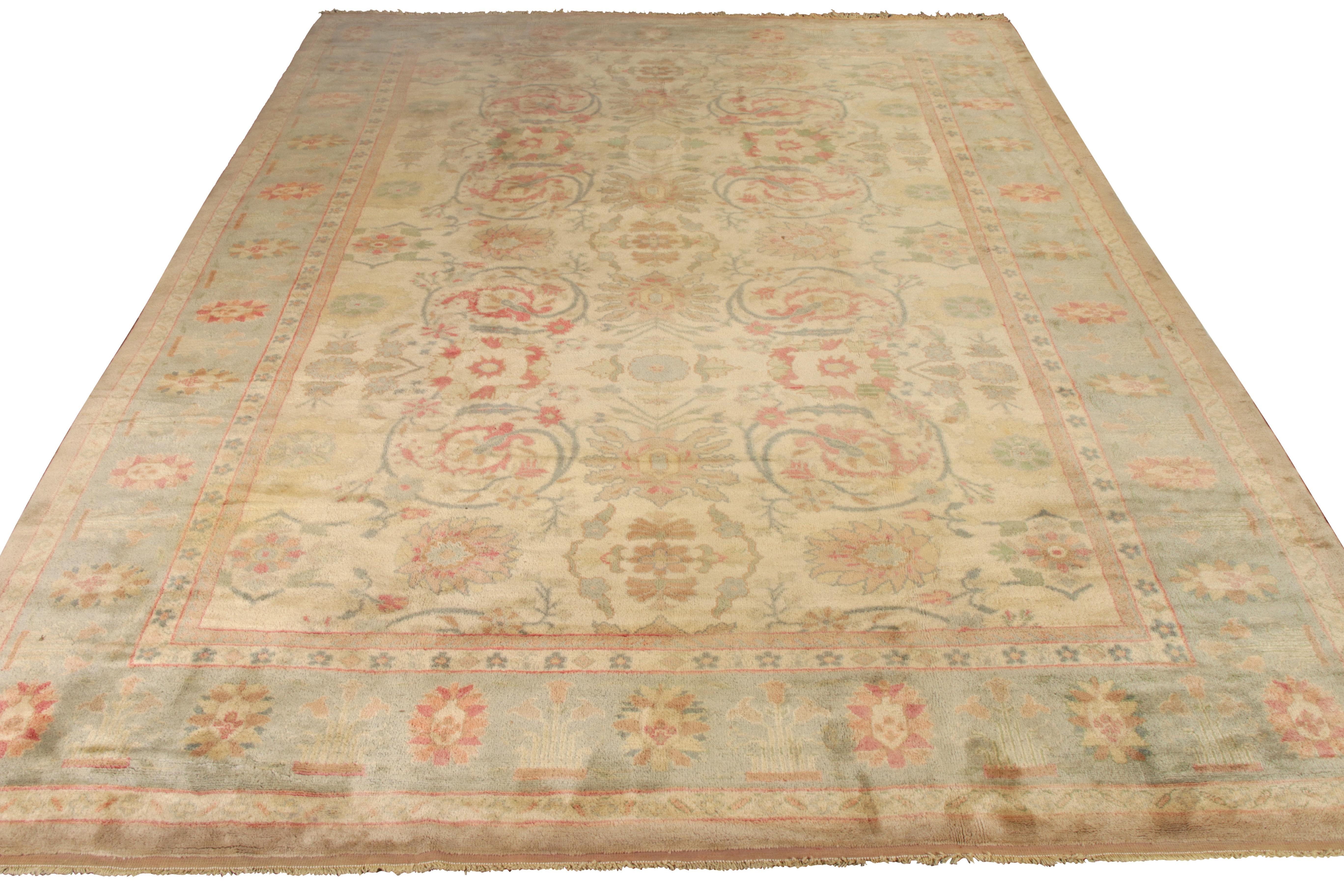 Hand knotted in wool originating circa 1970-1980, this 13 x 17 vintage rug from the Modern Classics Collection celebrates an Oushak rug style of renown in blue, green, and pink floral accents against the comfortable beige-brown background.

On the
