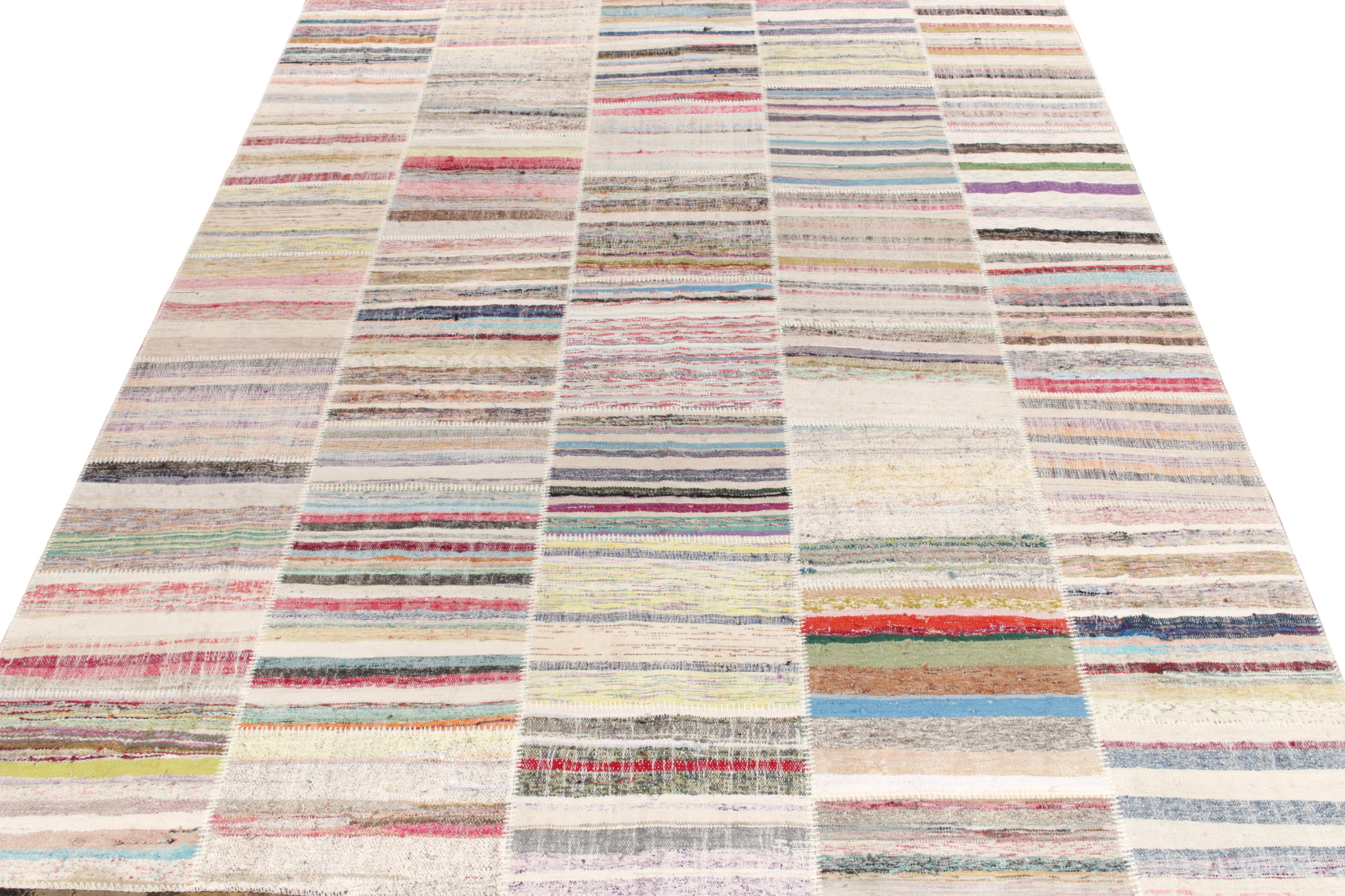 Rug & Kilim ist stolz darauf, seine künstlerische Vision von Patchwork-Kelims zu präsentieren, die Vintage-Garne zu einzigartigen Kunstwerken umgestalten. Dieses 9 x 12 große Sammlerstück zeichnet sich durch ein gestreiftes Muster aus, das in