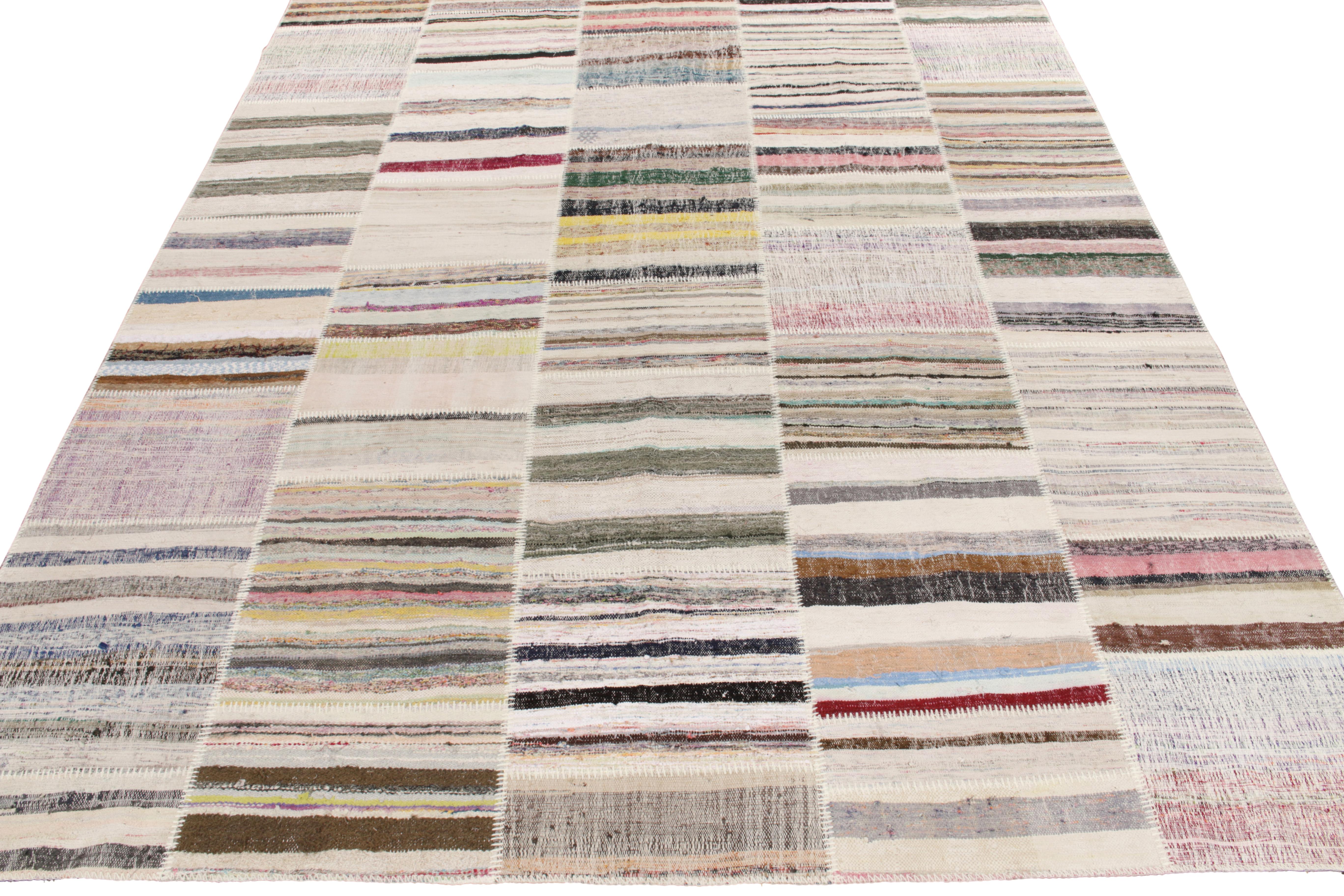 Rug & Kilim ist stolz darauf, seine künstlerische Vision von Patchwork-Kelims zu präsentieren, die Vintage-Garne zu einzigartigen Kunstwerken umgestalten. Dieses 9 x 12 große Sammlerstück zeichnet sich durch ein gestreiftes Muster aus, das in