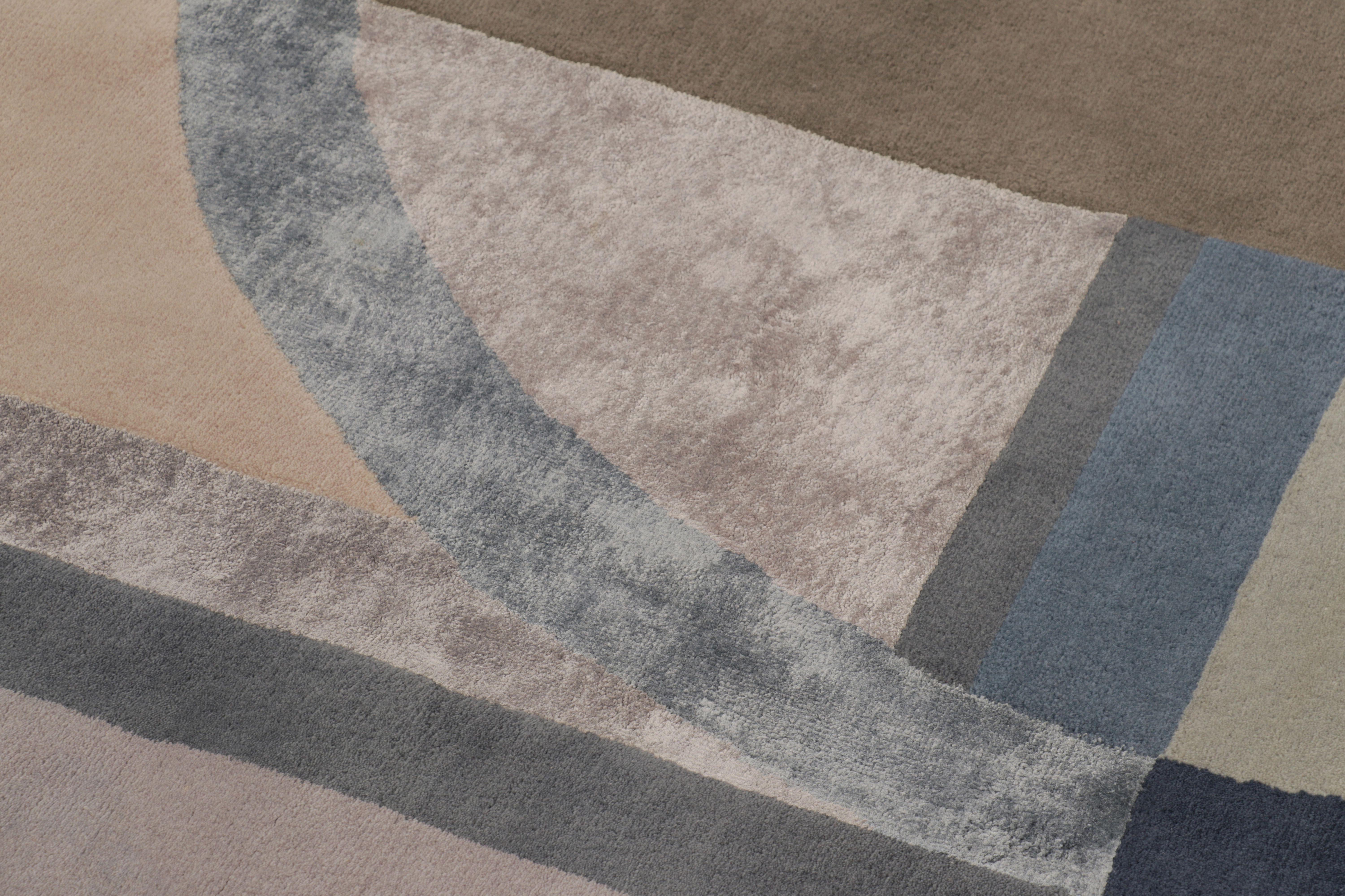 Questo magnifico tappeto moderno 12x12 è un vibrante capolavoro di astrazione geometrica. Annodato a mano in lana e viscosa lucida, il suo design presenta archi, rettangoli e cerchi intrecciati in sofisticate tonalità di blu ardesia, malva, rosa e