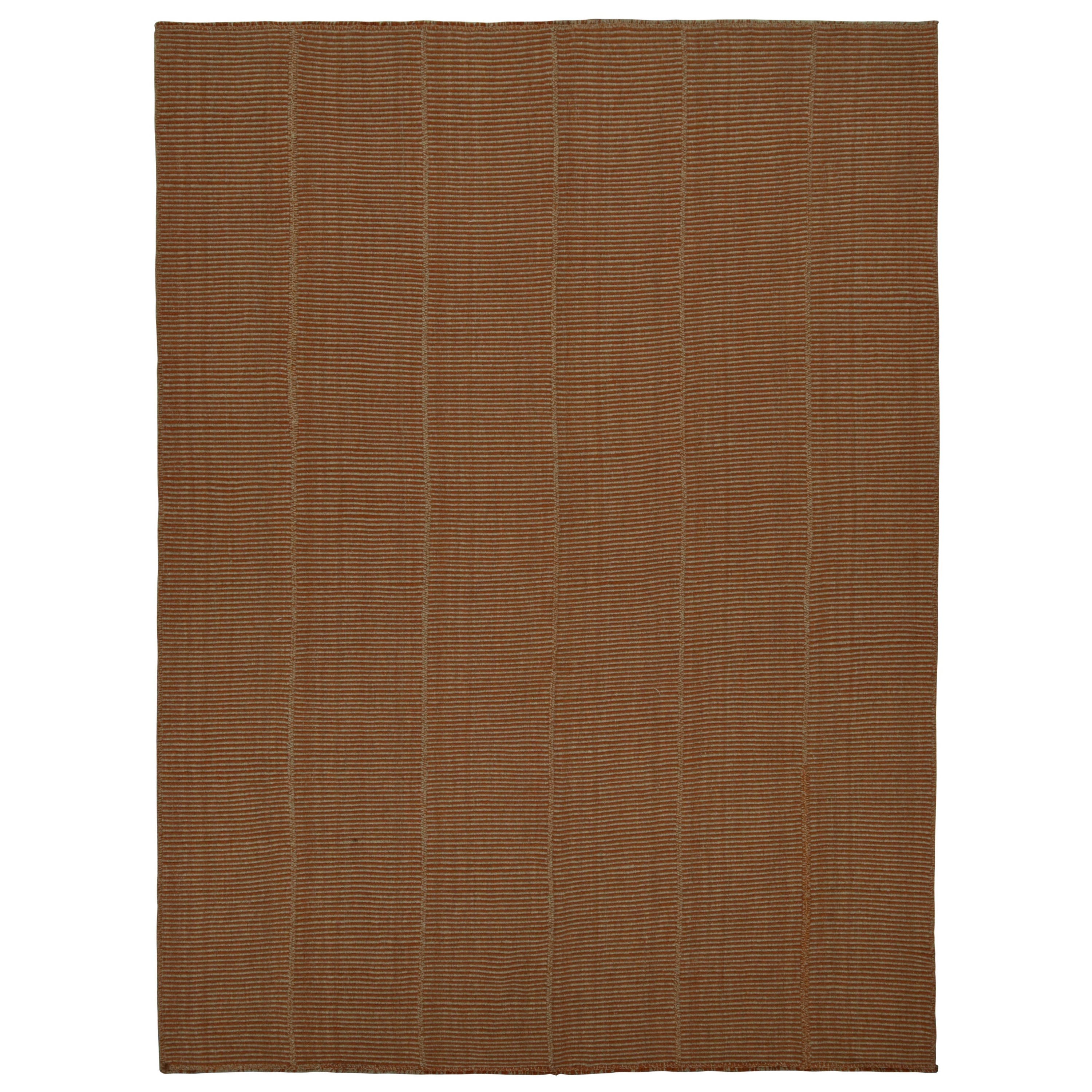 Rug & Kilim è un kilim moderno a strisce arancioni beige e ruggine con accenti taupe.