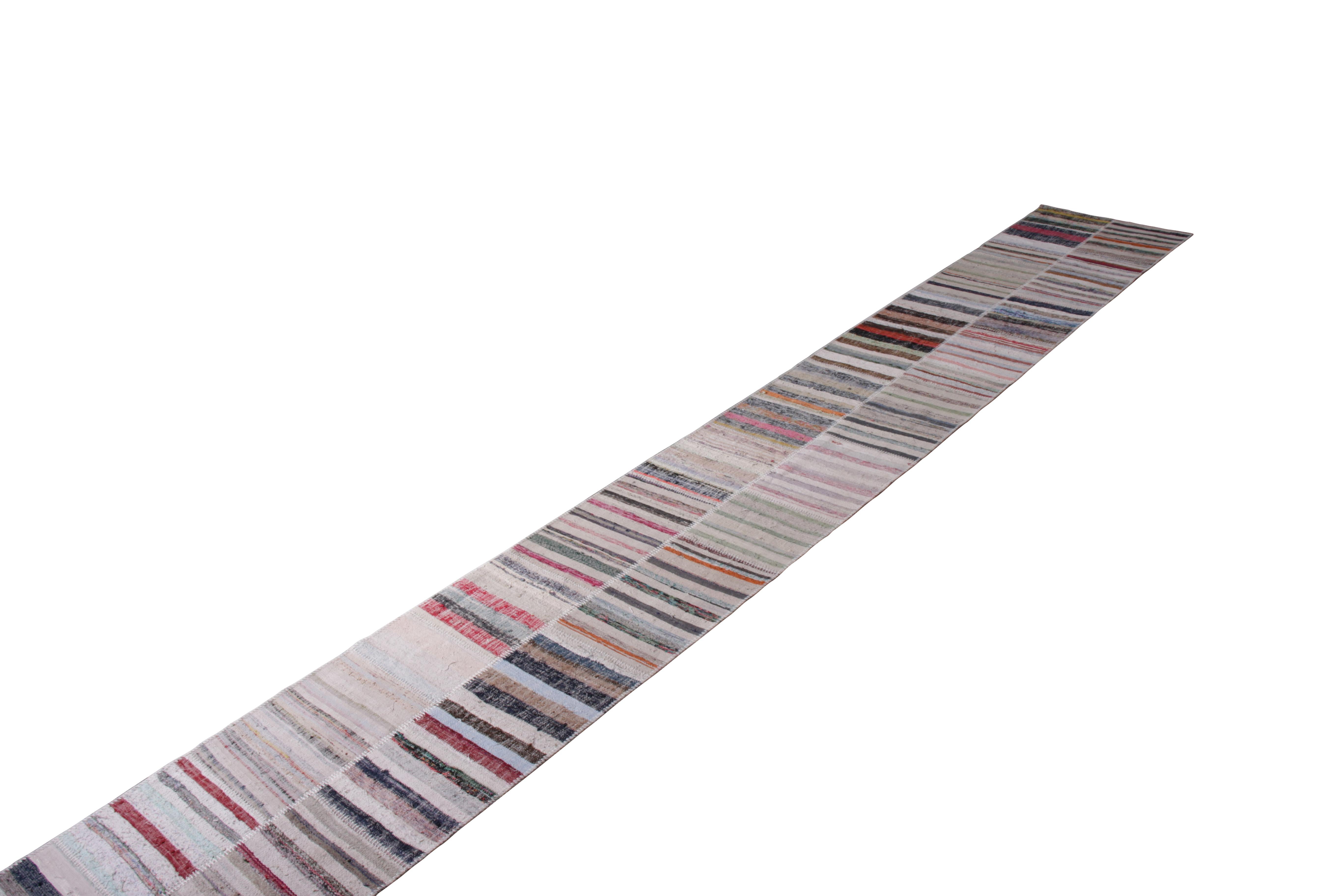 Handwoven in a wool flat-weave utilizing vintage yarns, this modern Kilim runner from Rug & Kilim’s Patchwork Kilim rug collection marries inspiration from midcentury Kilim rugs with a whimsical spectrum of red, blue, pink, green, and other