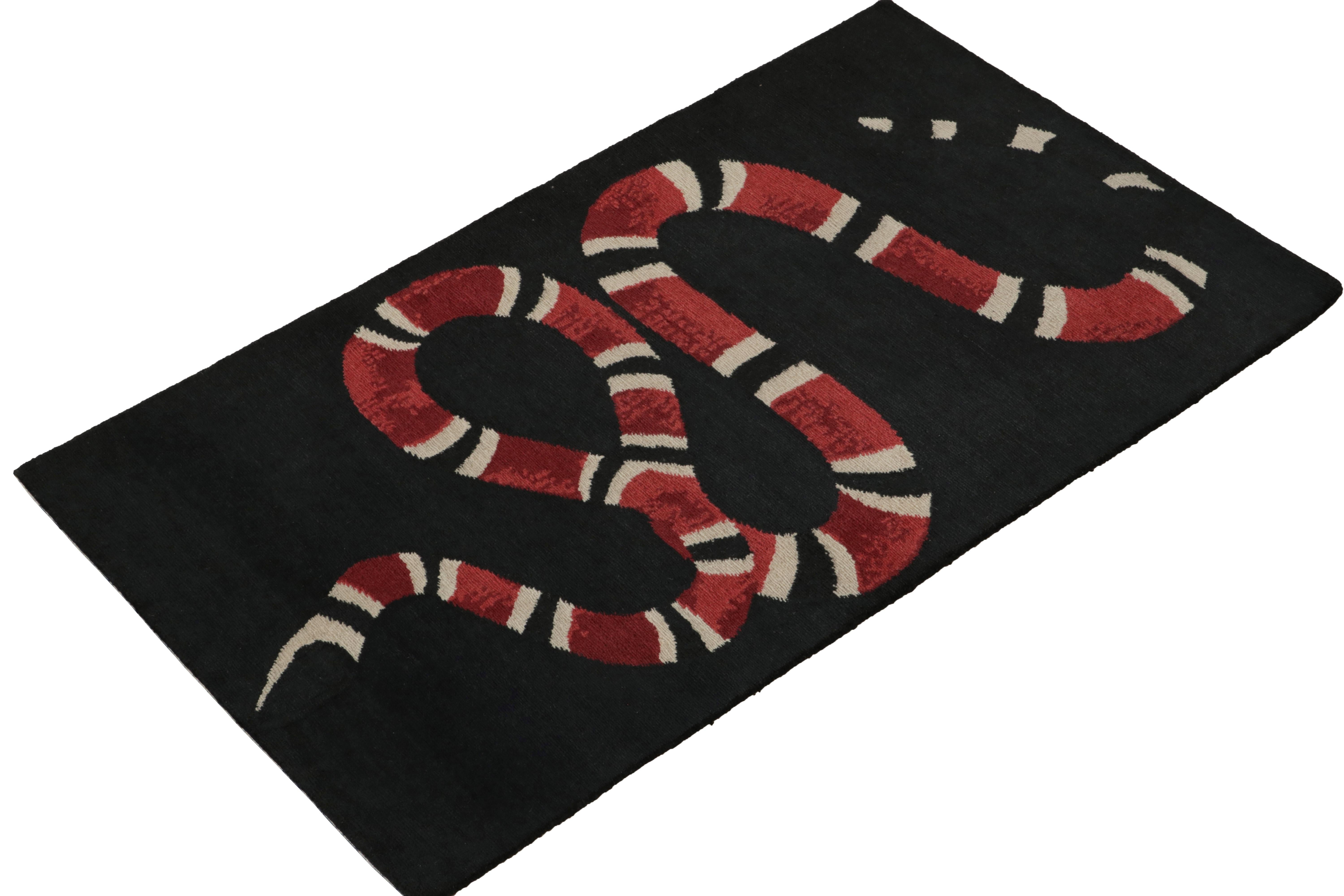 From Rug & Kilim’s bold modern selections, a 3x5 rug defining a playful new language in contemporary design. The rug showcases an interesting red & white snake pictorial meandering on charcoal black background for a striking visual appeal in such