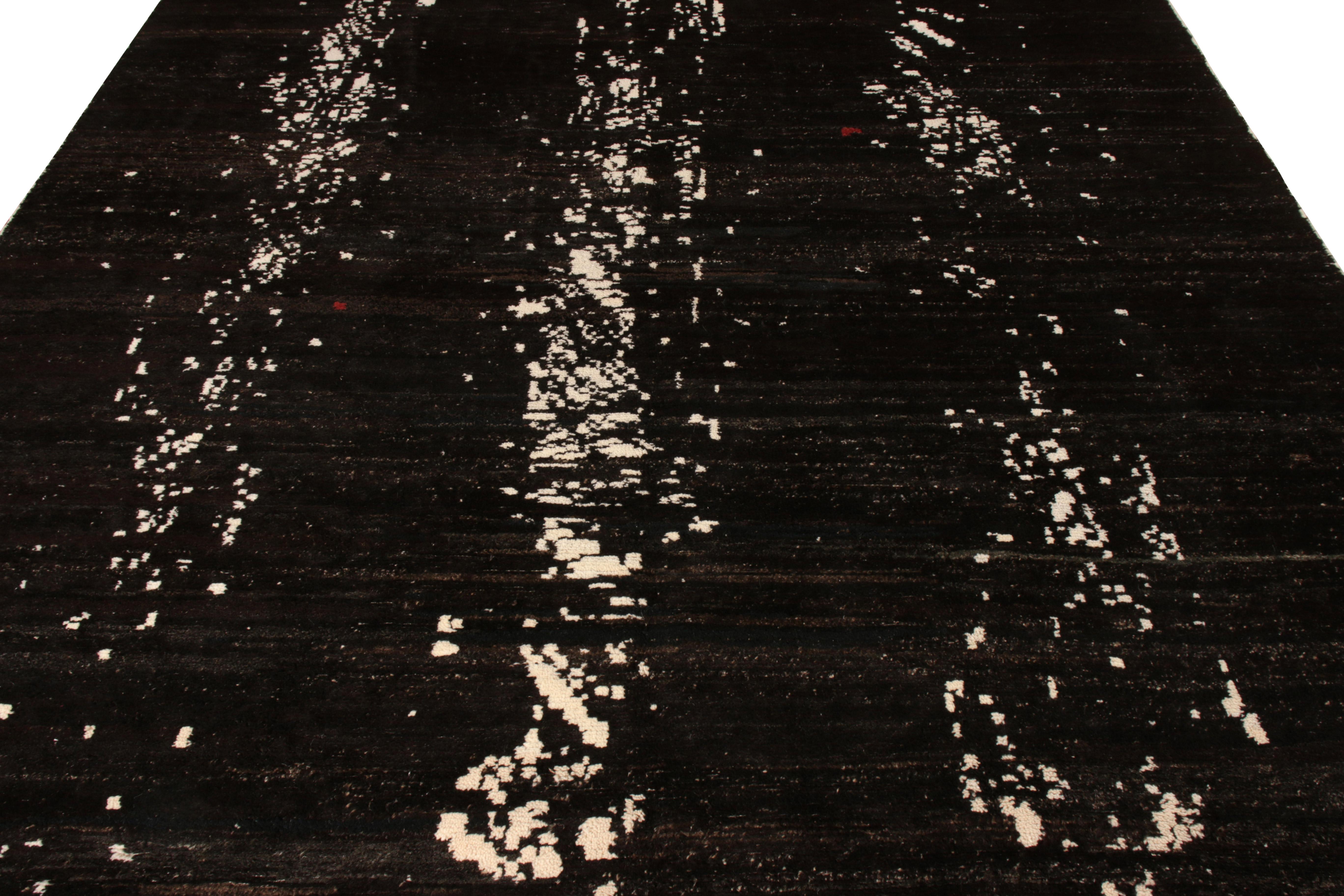 Un tapis abstrait 8 X 11 noué à la main de la collection New & Modern de Rug & Kilim. Fabriqué avec de la laine de poil de chèvre de qualité supérieure, ce tapis présente un délicieux motif superposé en blanc sur un riche dégradé de noir et de
