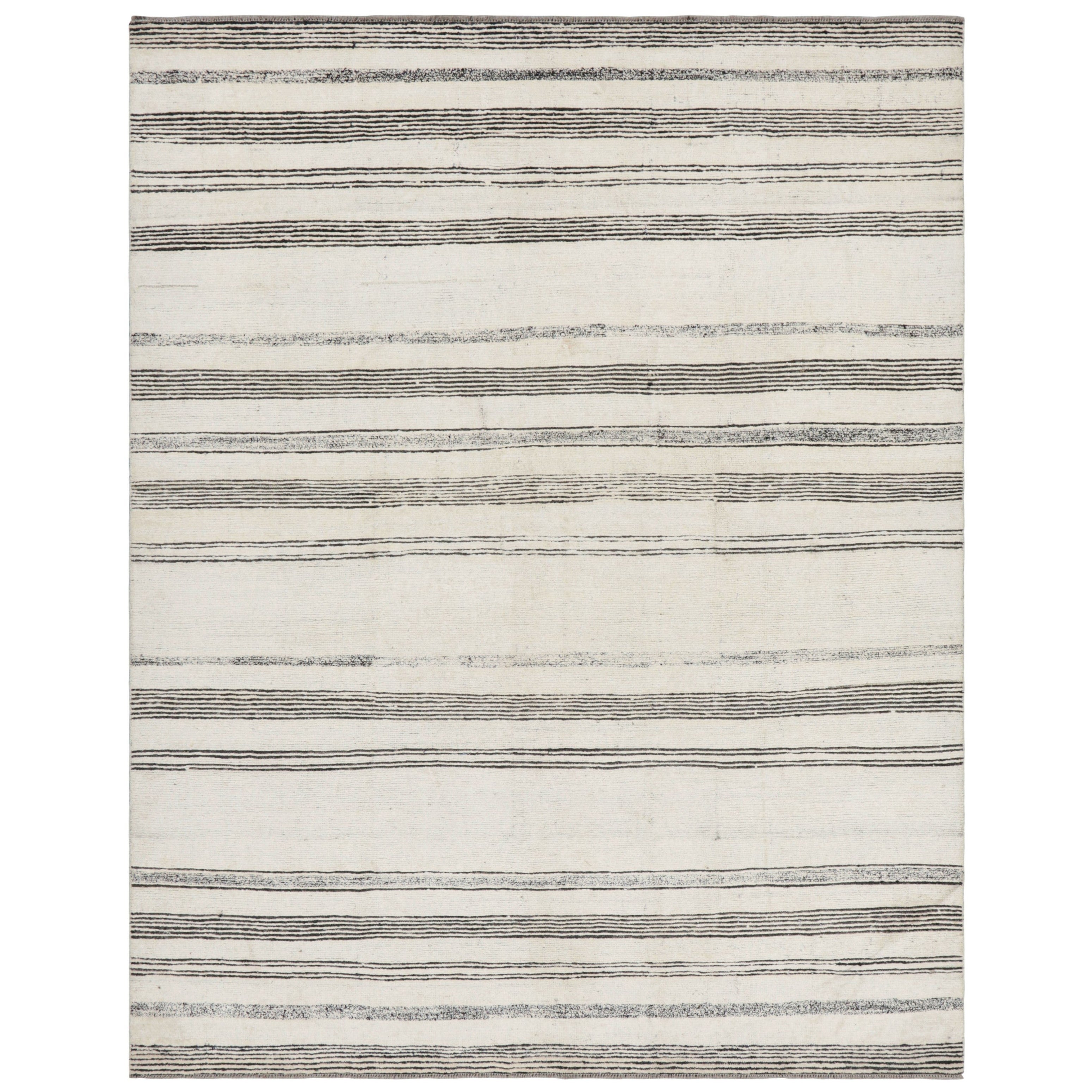 Rug
Kilim è un tappeto moderno in bianco con strisce e accenti testuali neri