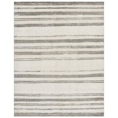 Rug
Kilim è un tappeto moderno in bianco con strisce e accenti testuali neri