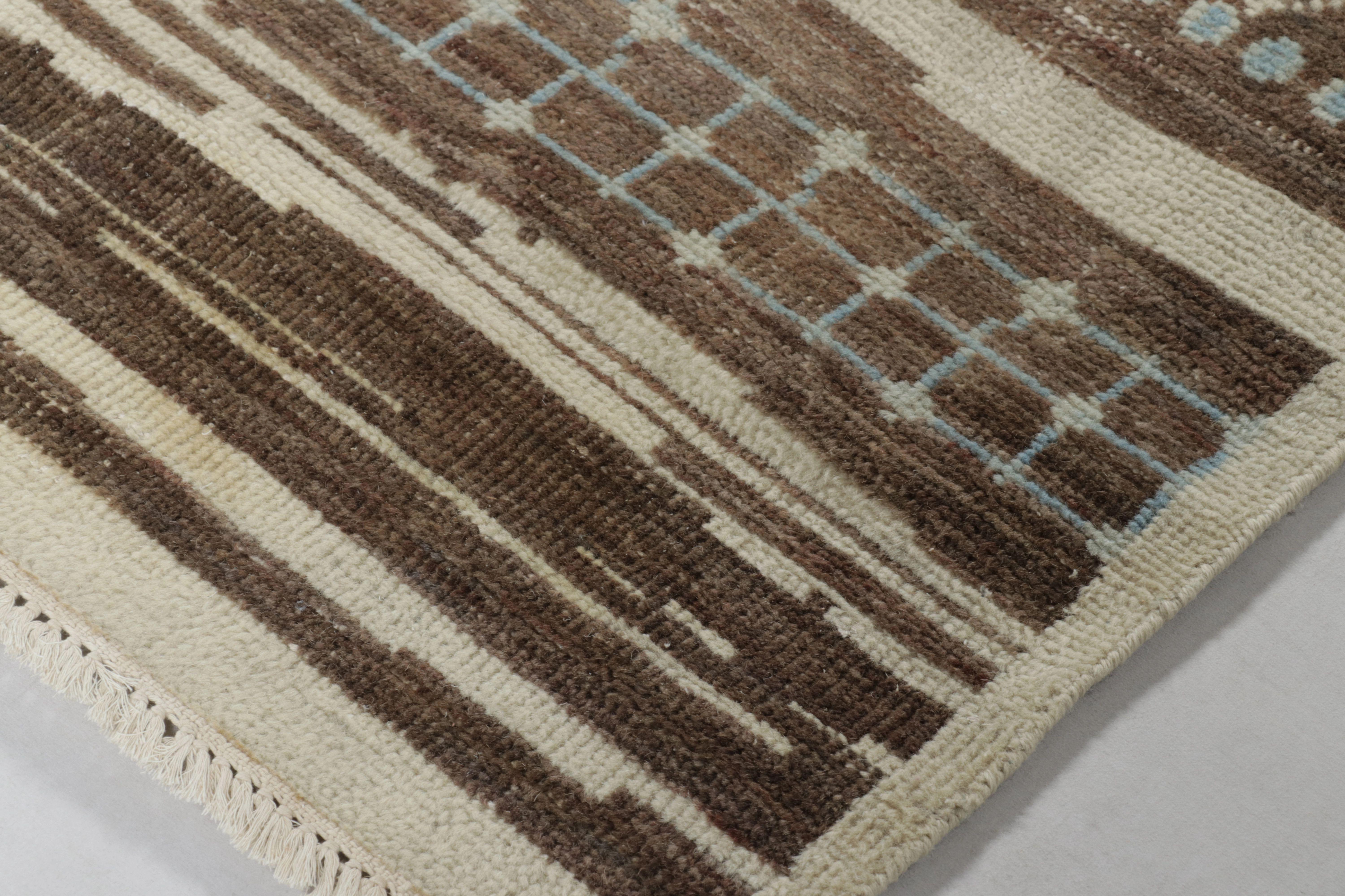 Questo magnifico tappeto 6x8 della Rug & Kilim's Moroccan Collection è un ricco pezzo di ispirazione marocchina, annodato a mano interamente in lana pregiata. Il disegno presenta un campo marrone sbiadito interrotto da bande di avorio cremoso che