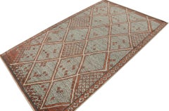 Rug & Kilim è un tappeto in stile marocchino con motivi a rombi rossi e grigi.