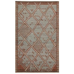 Rug & Kilim è un tappeto in stile marocchino con motivi a rombi rossi e grigi.