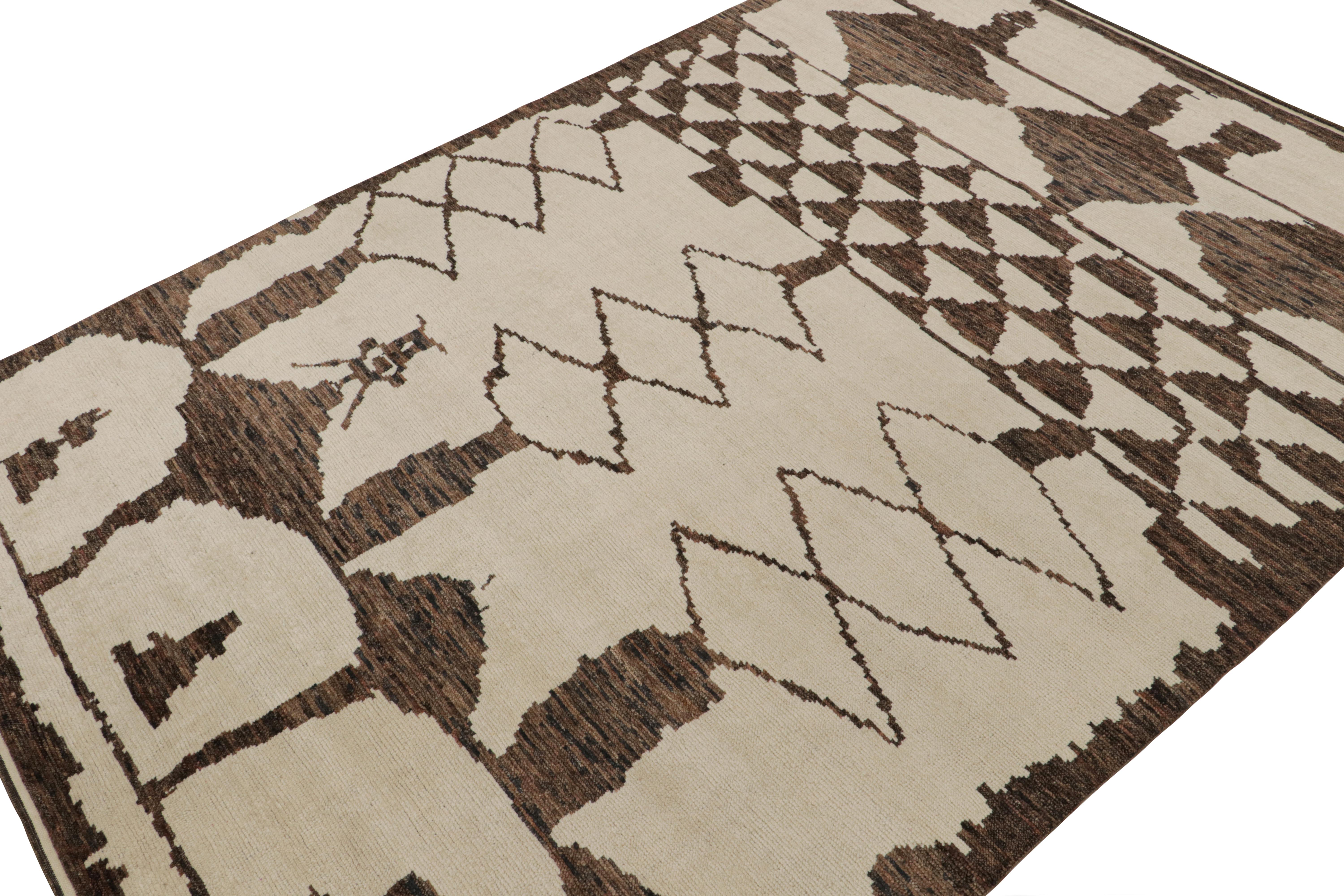 Hand-knotted in wool, this 10x14 contemporary rug is a new addition to the Moroccan rug collection by Rug & Kilim. 

On the Design

This rug enjoys a cream and beige undertone with chocolate brown lozenges and other geometric patterns of primitivist