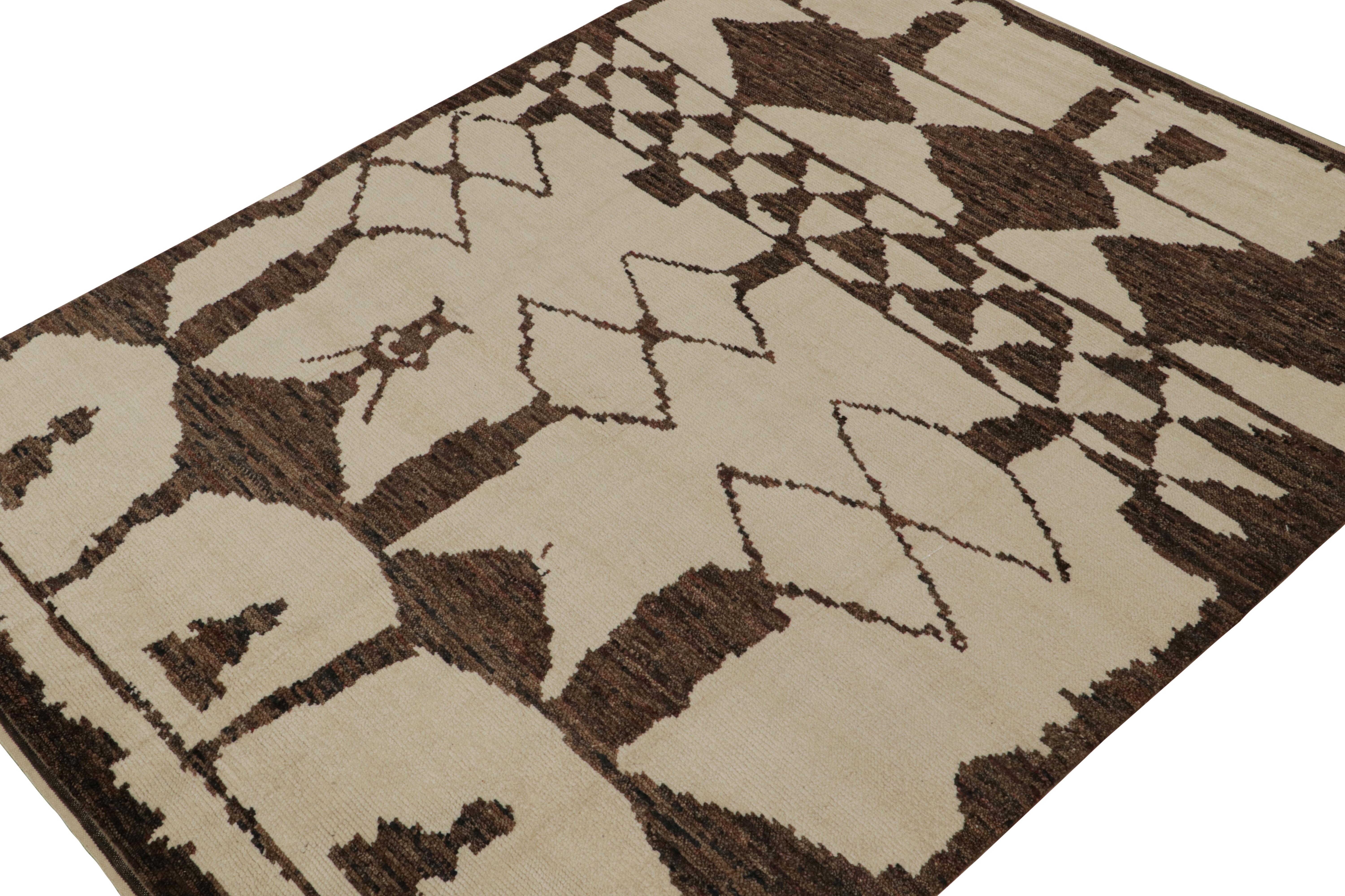 Hand-knotted in wool, this 10x14 contemporary rug is a new addition to the Moroccan rug collection by Rug & Kilim. 

On the Design

This rug enjoys a cream and beige undertone with chocolate brown lozenges and other geometric patterns of primitivist