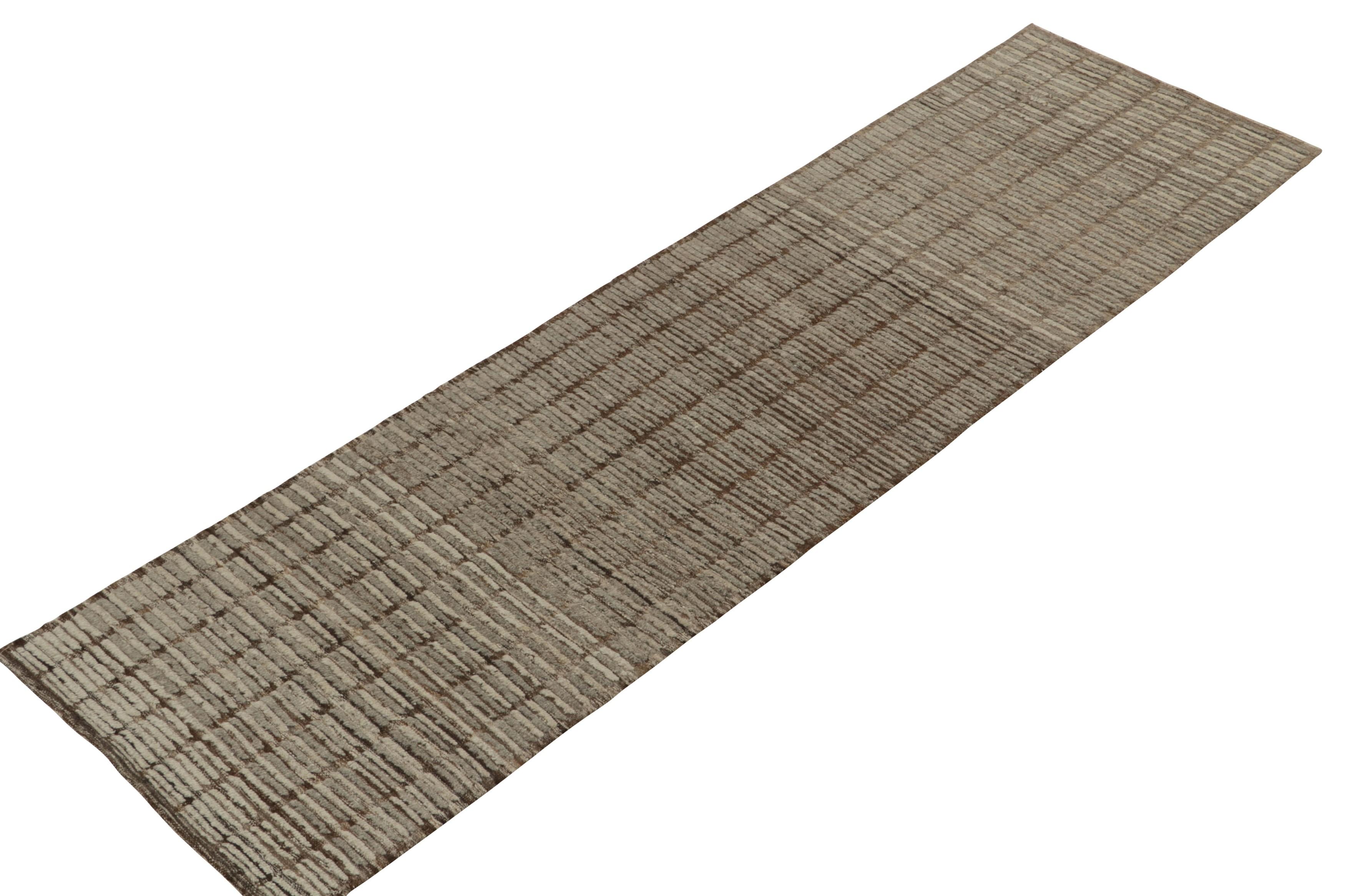 Parmi les sélections classiques modernes de Rug & Kilim, un chemin de table 4x10 noué à la main et inspiré des tapis tribaux marocains. La vision est celle d'un mariage de riches tons bruns et gris qui s'inscrivent magnifiquement dans un motif strié