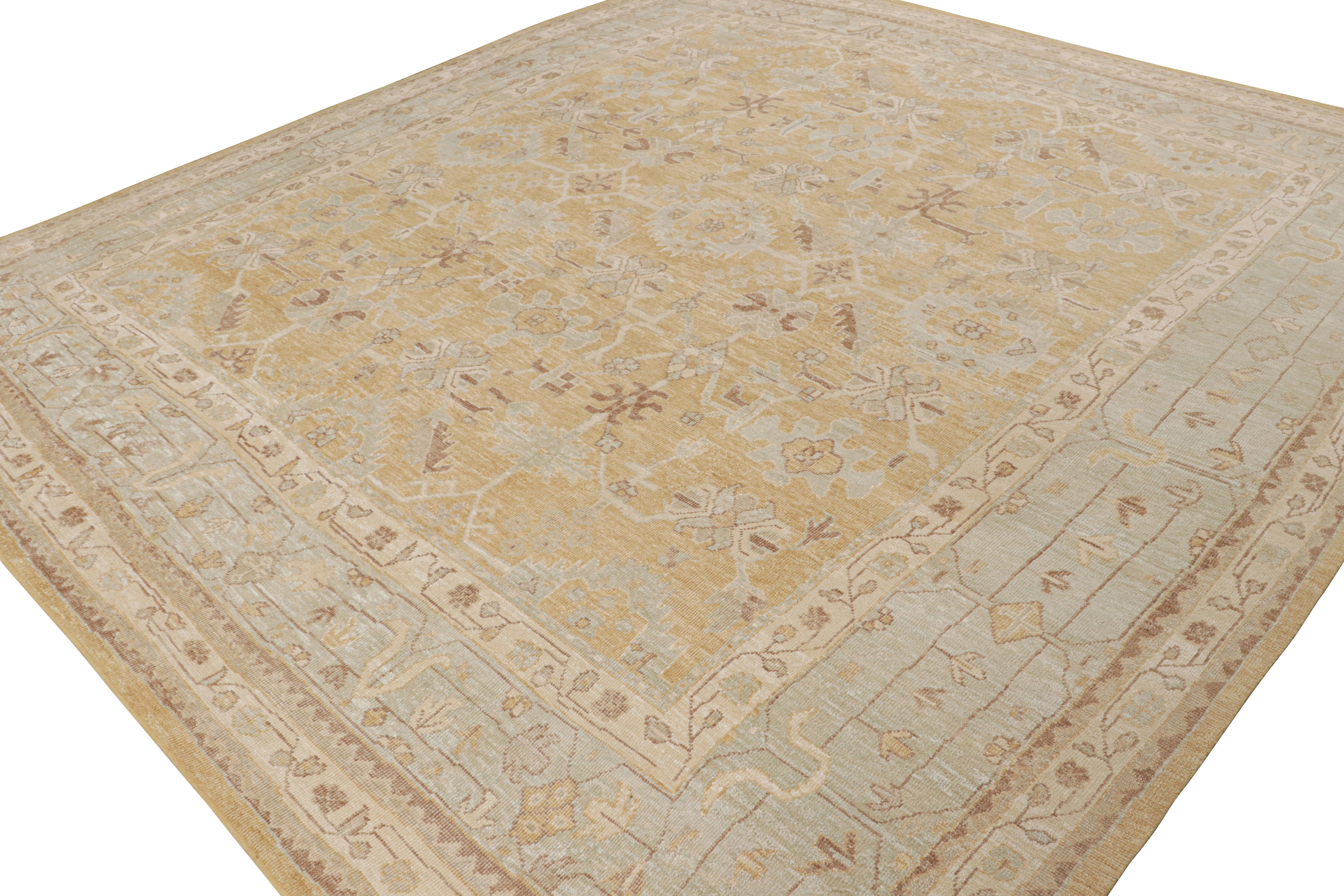 Ce tapis 12x13 de la Collection S S est caractérisé par un champ doré, des bordures bleues et beige-brun soulignant des motifs géométriques-floraux conformes au style Oushak. 

Sur le design : 

Les connaisseurs admireront le fait que ce tapis est