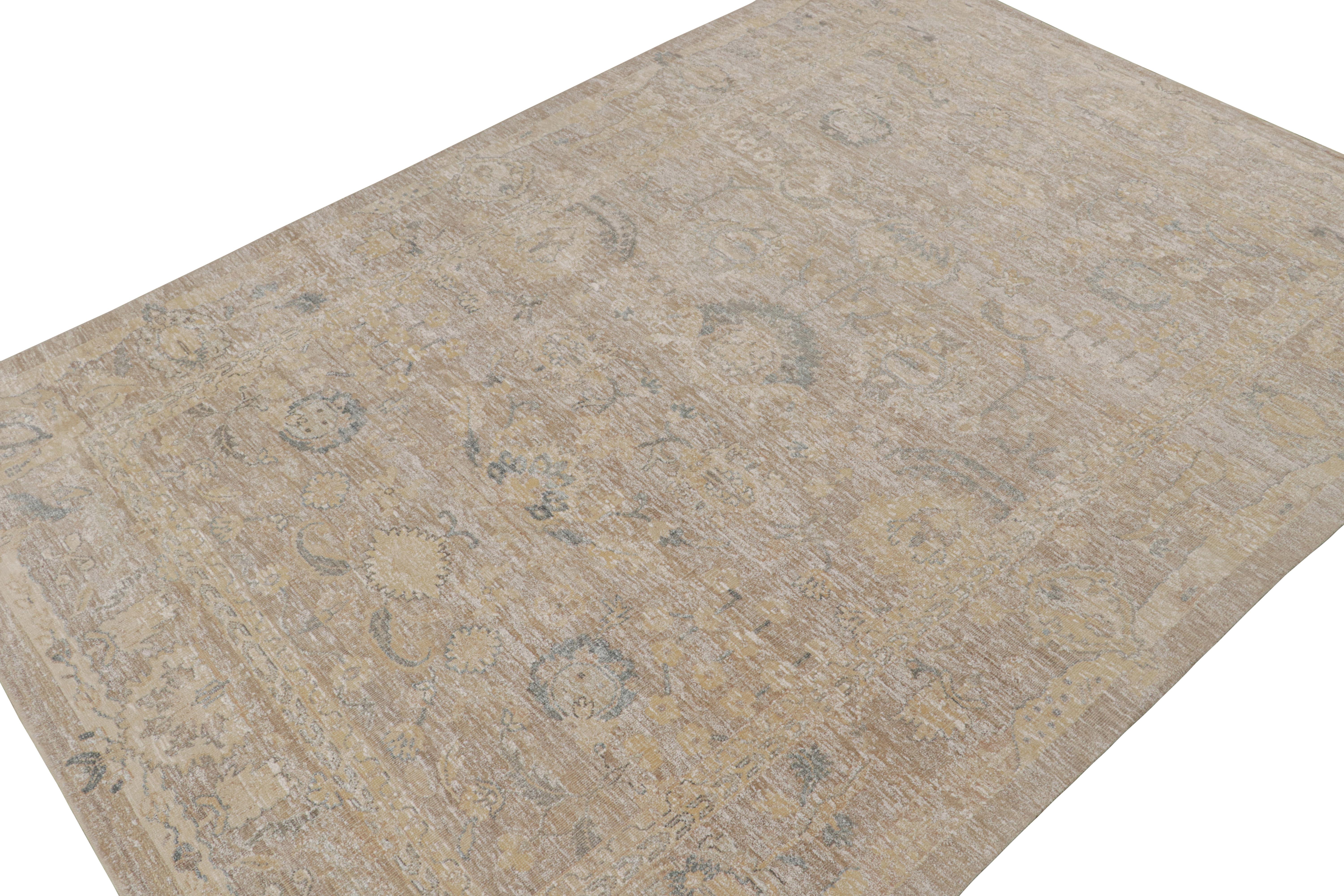 This 10x14 rug is inspired by antique Oushak rugs—from a bold new Modern Classics Collection by Rug & Kilim. Hand-knotted in silk, it enjoys taupe and beige-brown undertones with tribal motifs and floral patterns in blue and gold tones. 

On the