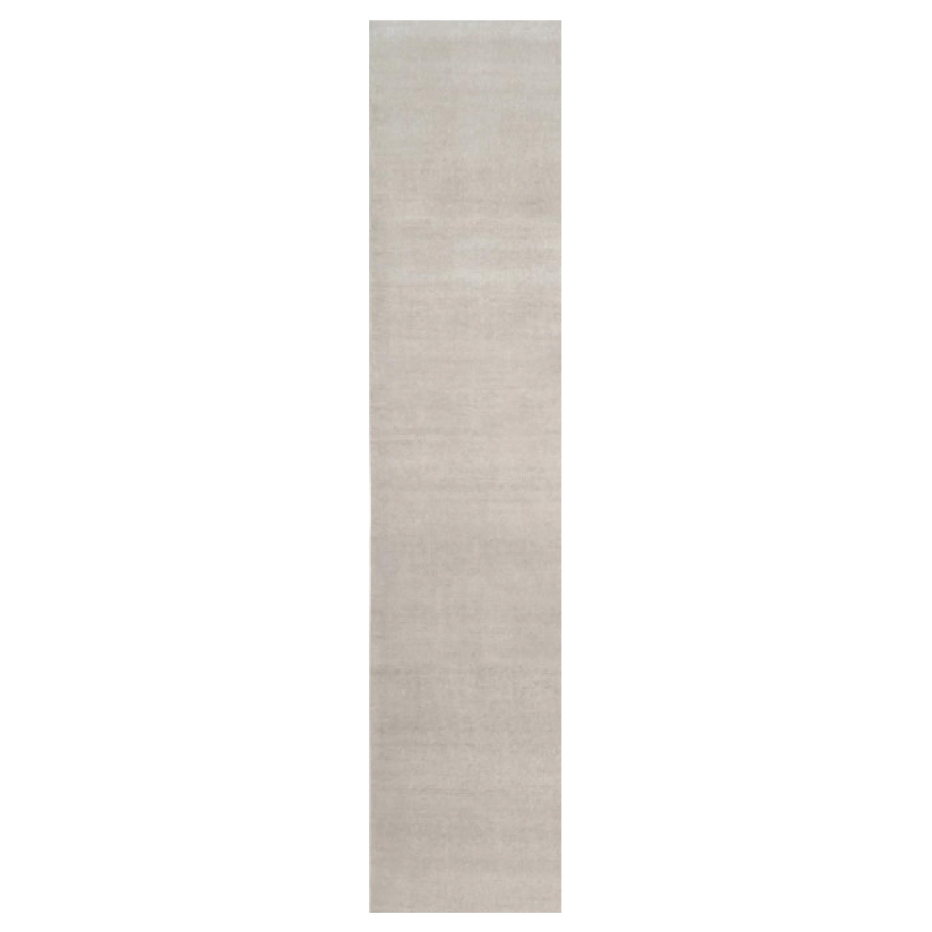 Rug & Kilim è un tappeto solido contemporaneo oversize dai toni avorio.