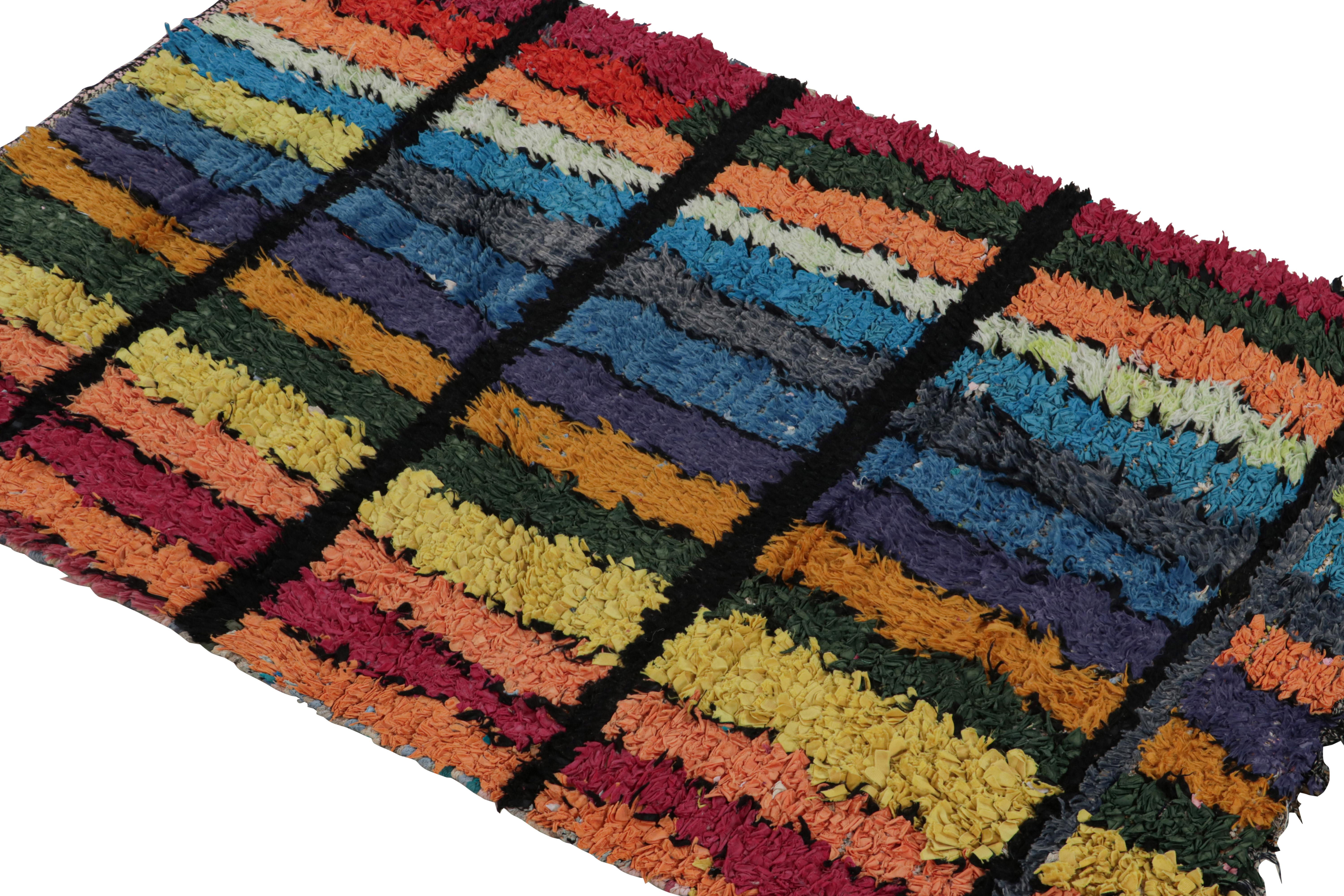 Hand-knotted in wool and fabric circa 1950-1960, this vintage 3x5 Moroccan Boucherouite rug is believed to hail from the Azilal tribe. 

On the Design: 

This rug enjoys a play of rainbow tones of red, green, blue and green in the geometric