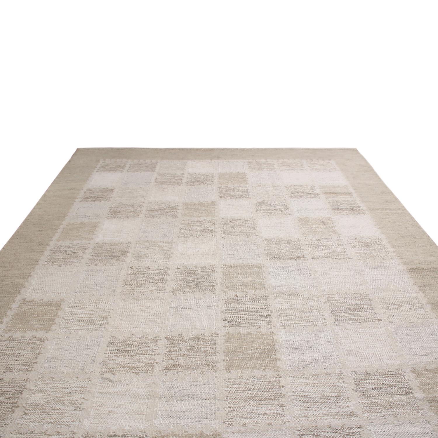 Originating from India, this hand knotted wool pile rug hails from Rug & Kilim’s Scandinavian-inspired collection, featuring a distinct tribal geometric all-over field design with off-white, gray, and multi-tonal beige brown colorways bound in