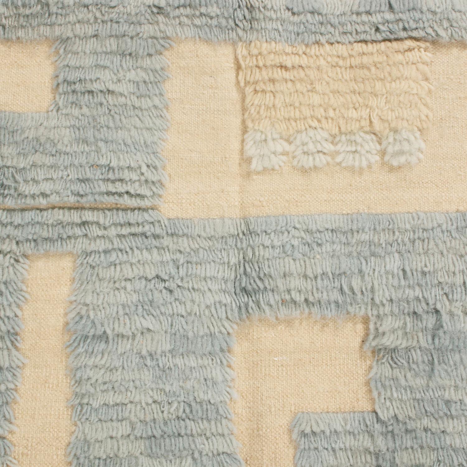 Originating from India, this hand knotted contemporary pile rug hails from Rug & Kilim’s Scandinavian-inspired collection, featuring a distinct tribal and raised pile geometric all-over field design with gentle blue, off-white, gray, and multi-tonal