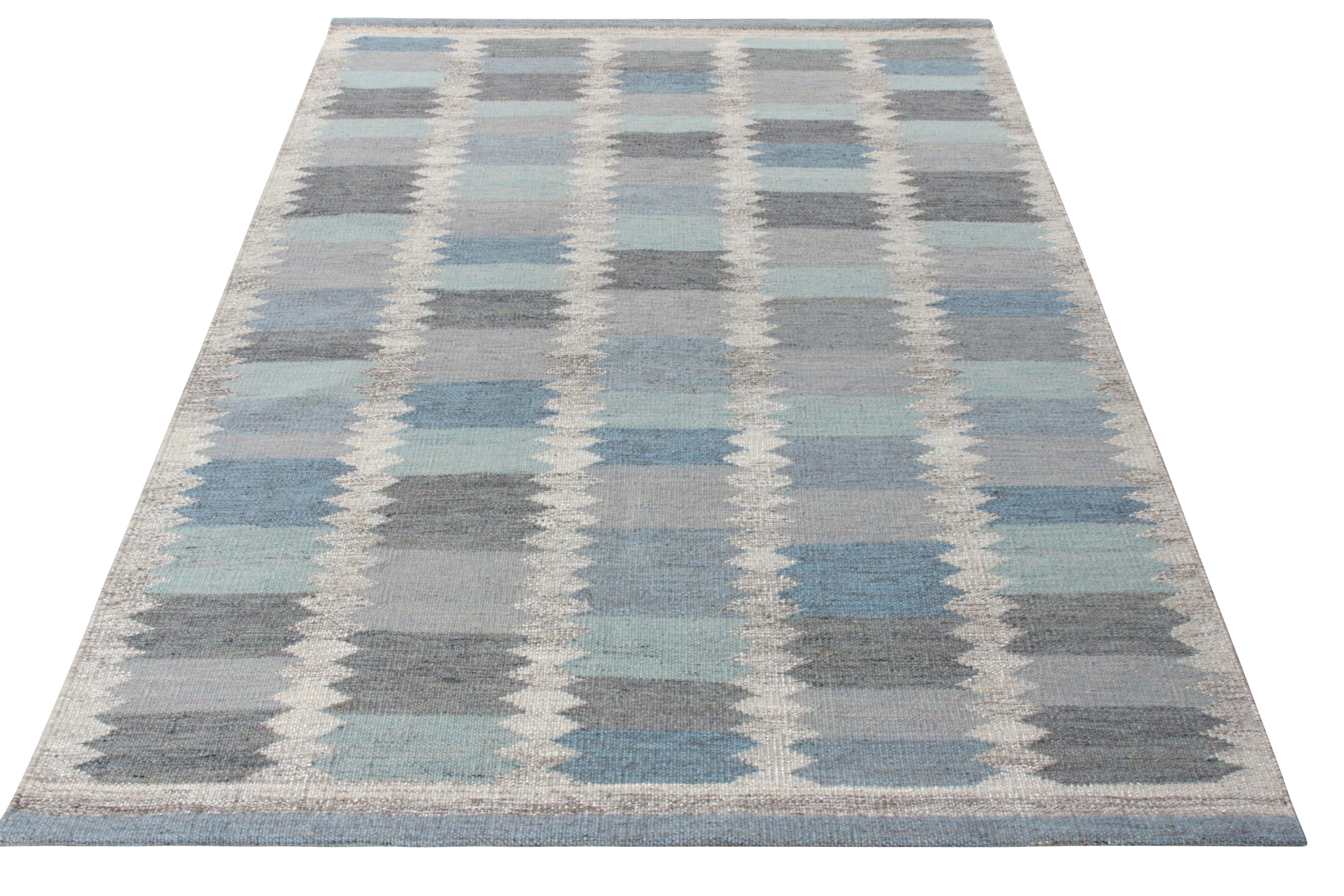 A 6x9 handwoven wool Kilim from Rug & Kilim’s award-winning Scandinavian flat weave collection. Featuring a symmetric horizontal striation in shades of blue & gray, the rug enjoys a scintillating sense of movement with a series of diamond patterns