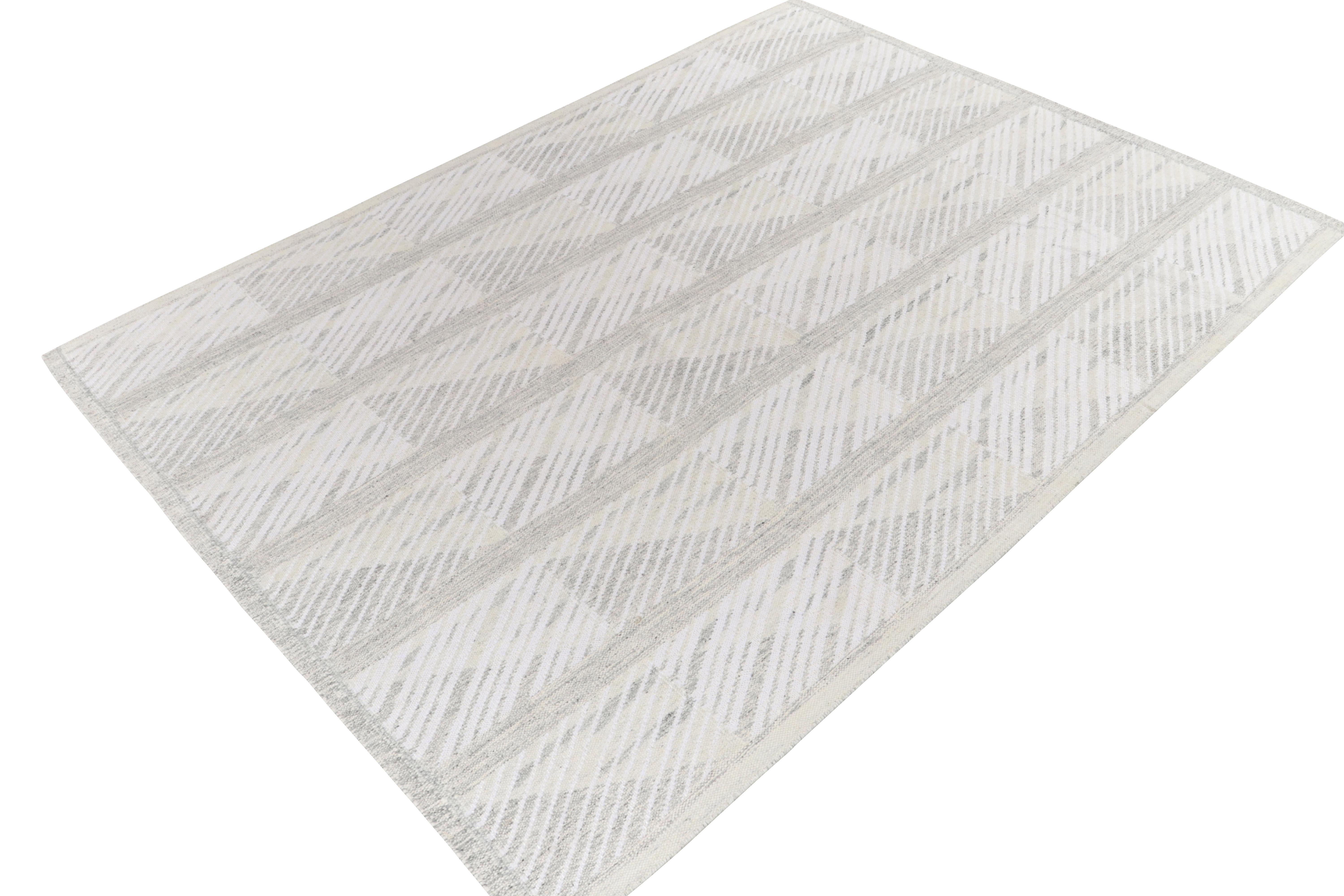 Tissé à la main dans une laine de qualité, ce kilim 9x12 vient s'ajouter à nos textures scandinaves primées à tissage plat. Ce tapis contemporain présente un motif déco géométrique net avec des stries en gris, blanc et beige pour un mouvement