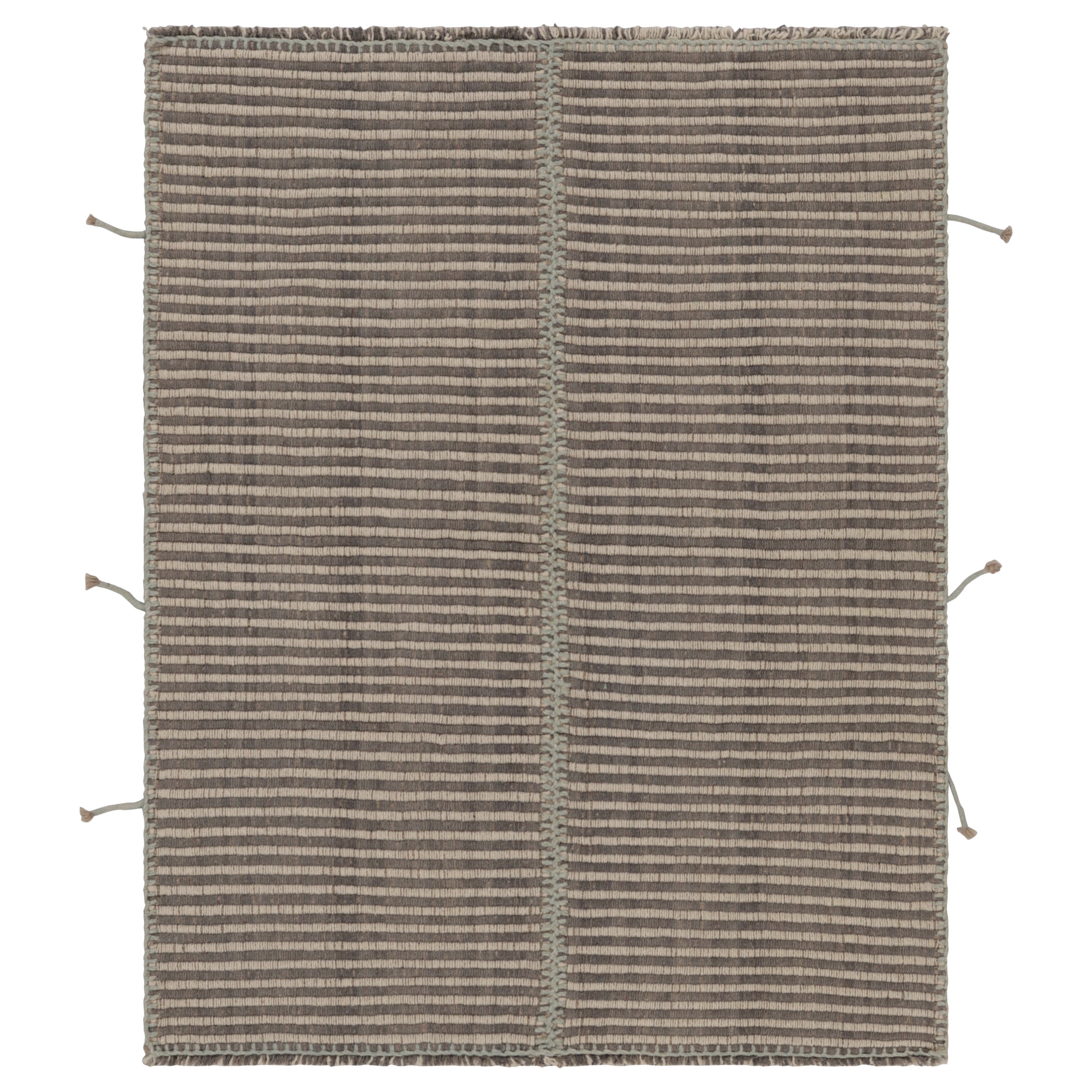 Rug & Kilim è un tappeto quadrato a strisce verdi e azzurre con accenti testuali.
