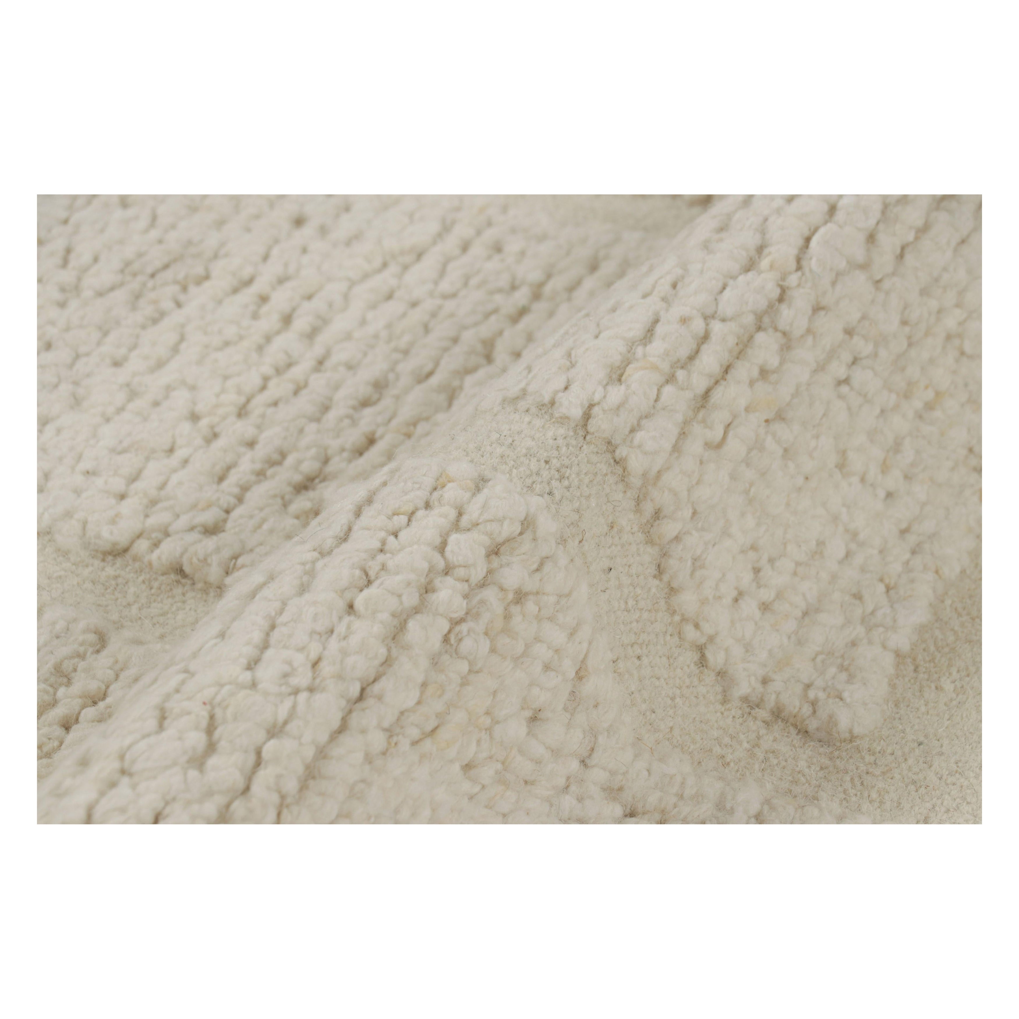 Rug & Kilim è un tappeto strutturato di colore bianco crema con motivi geometrici alti e bassi.
