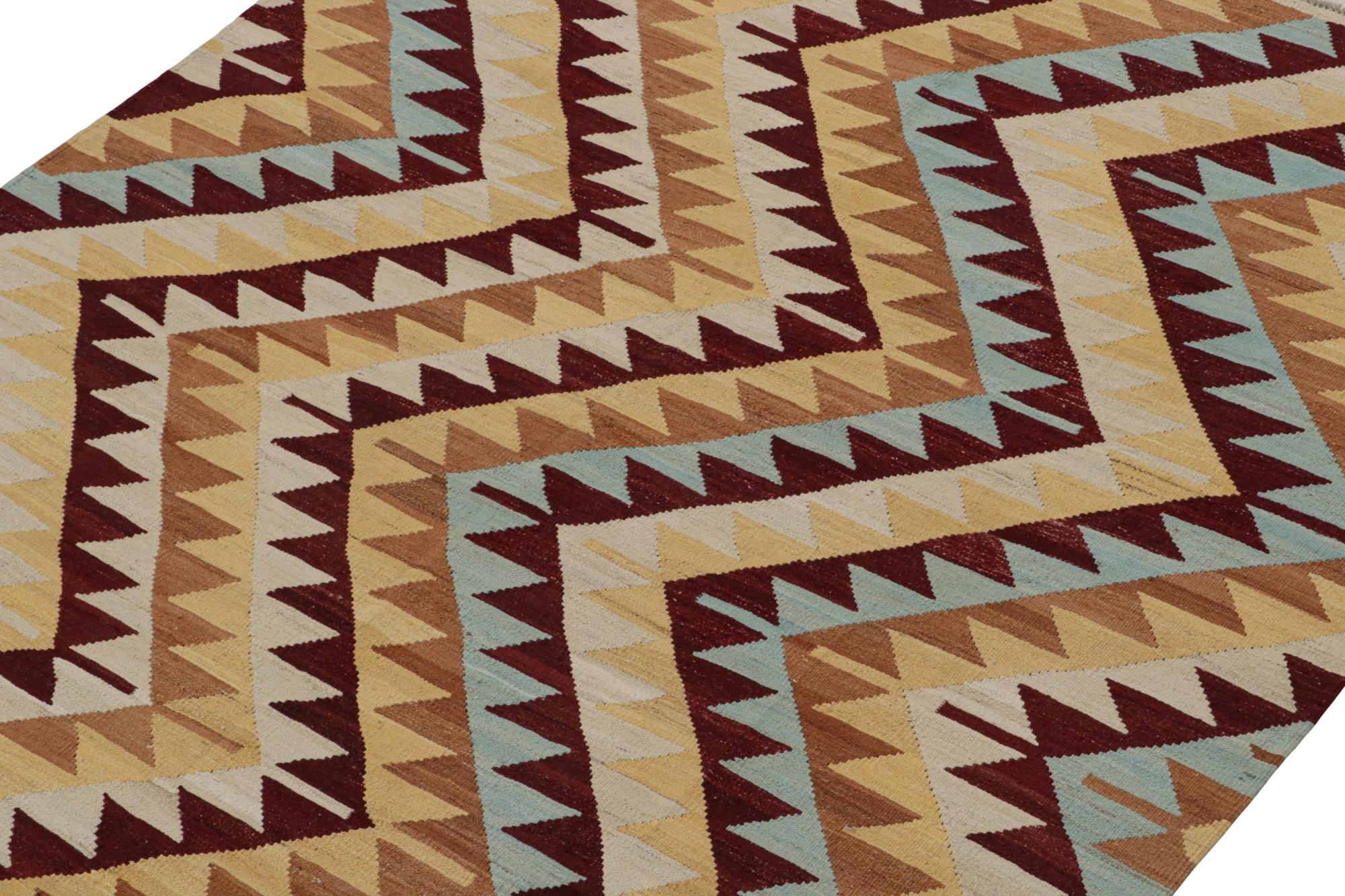 Handwoven in wool, this contemporary 7x8 Kilim by Rug & Kilim is inspired by antique tribal Kilims and flatweaves. 

On the Design:

This area rug enjoys a play of chevrons and geometric patterns in burgundy, beige-brown, sky blue and gold hues.