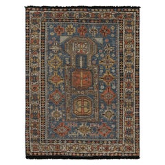 Rug & Kilim è un tappeto in stile tribale in blu con motivi geometrici rossi e dorati