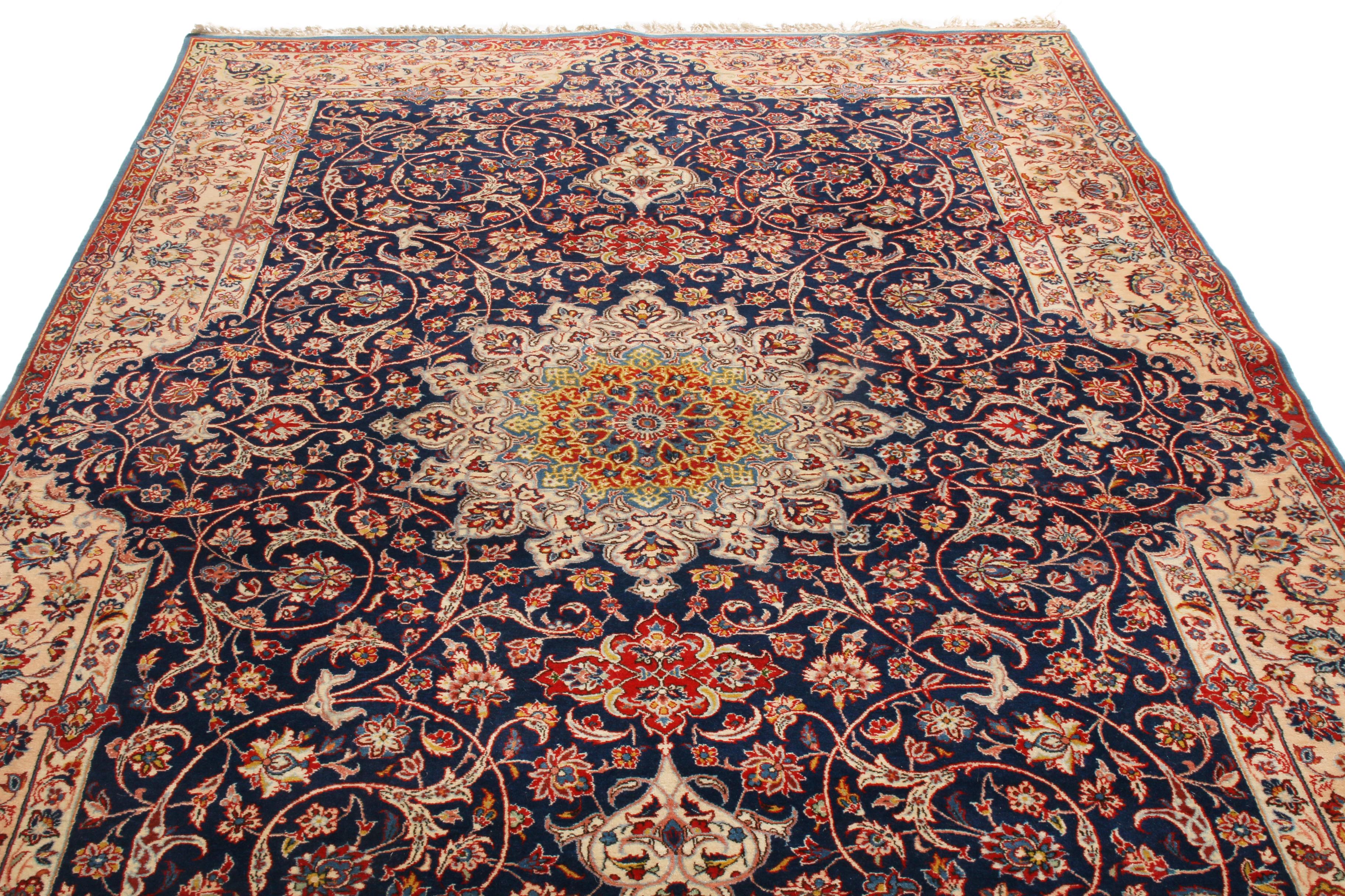 Originating from Persia in 1940, this vintage traditional Isfahan rug employs one of the most finely woven variations of the Islamic pattern enfolding its medallion field design. Hand knotted in fine, high-quality wool, the Islamic pattern is seen
