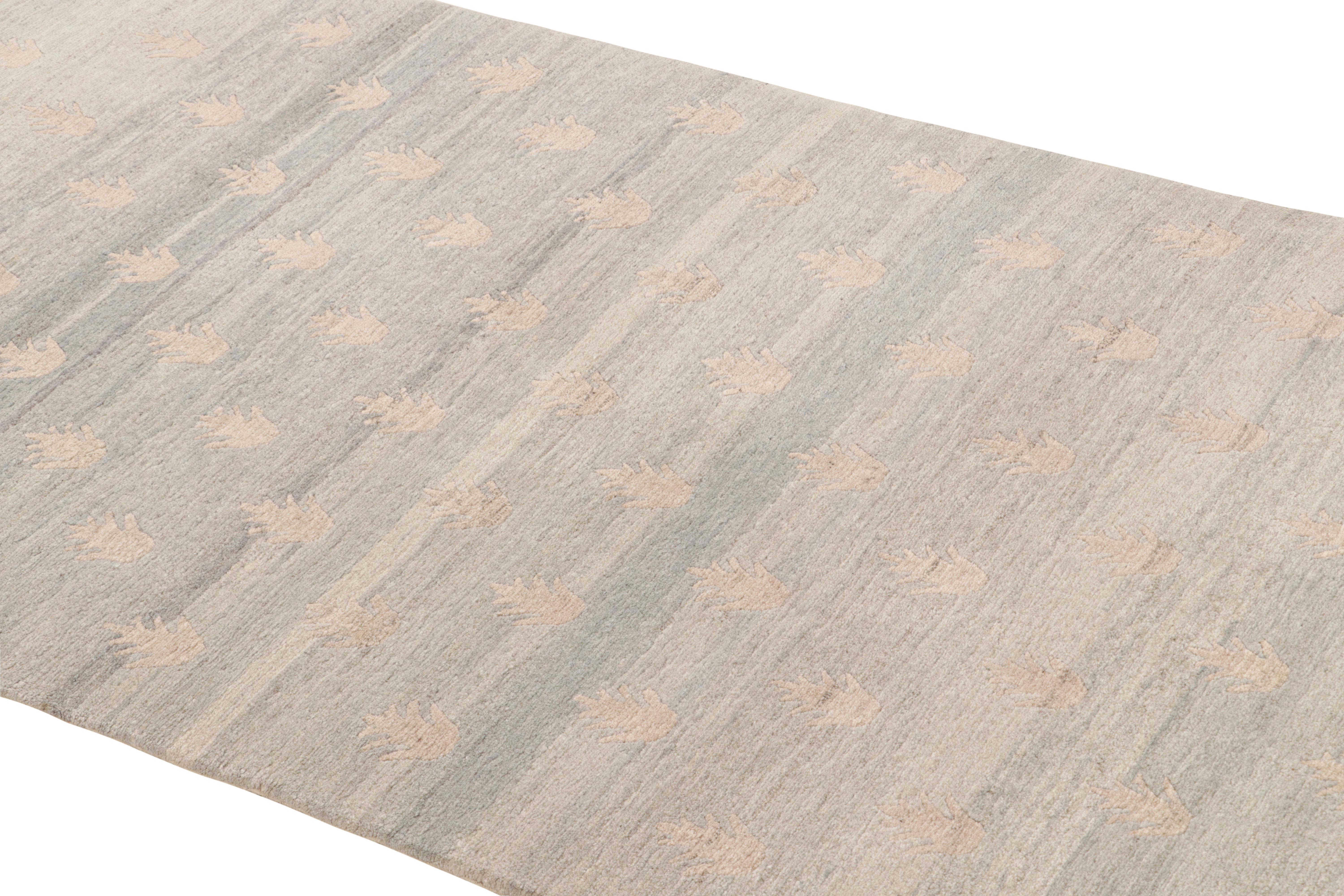 Anudada a mano con lana duradera procedente de Nepal, esta alfombra de lana contemporánea presenta un exclusivo motivo geométrico Youngster en gris plateado industrial abrash, que alberga pronunciados medallones crema y motivos de chevron rojo,