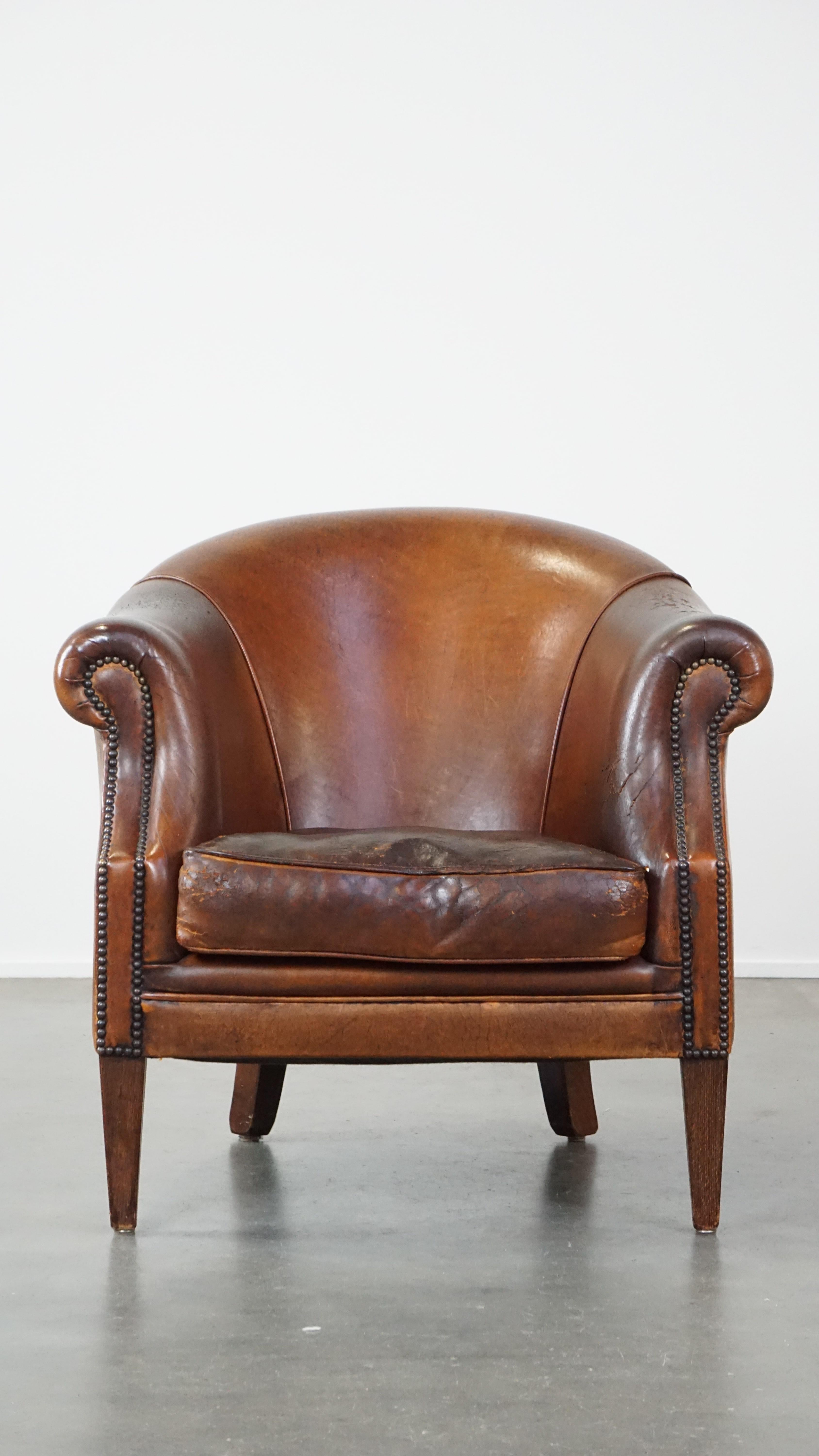 This fantastic vintage club chair, made of sheepskin, easily fits into almost any interior. It has a sleek finish and exudes character from every angle. The chair features a loose seat cushion and offers the comfort you'd expect. Due to years of