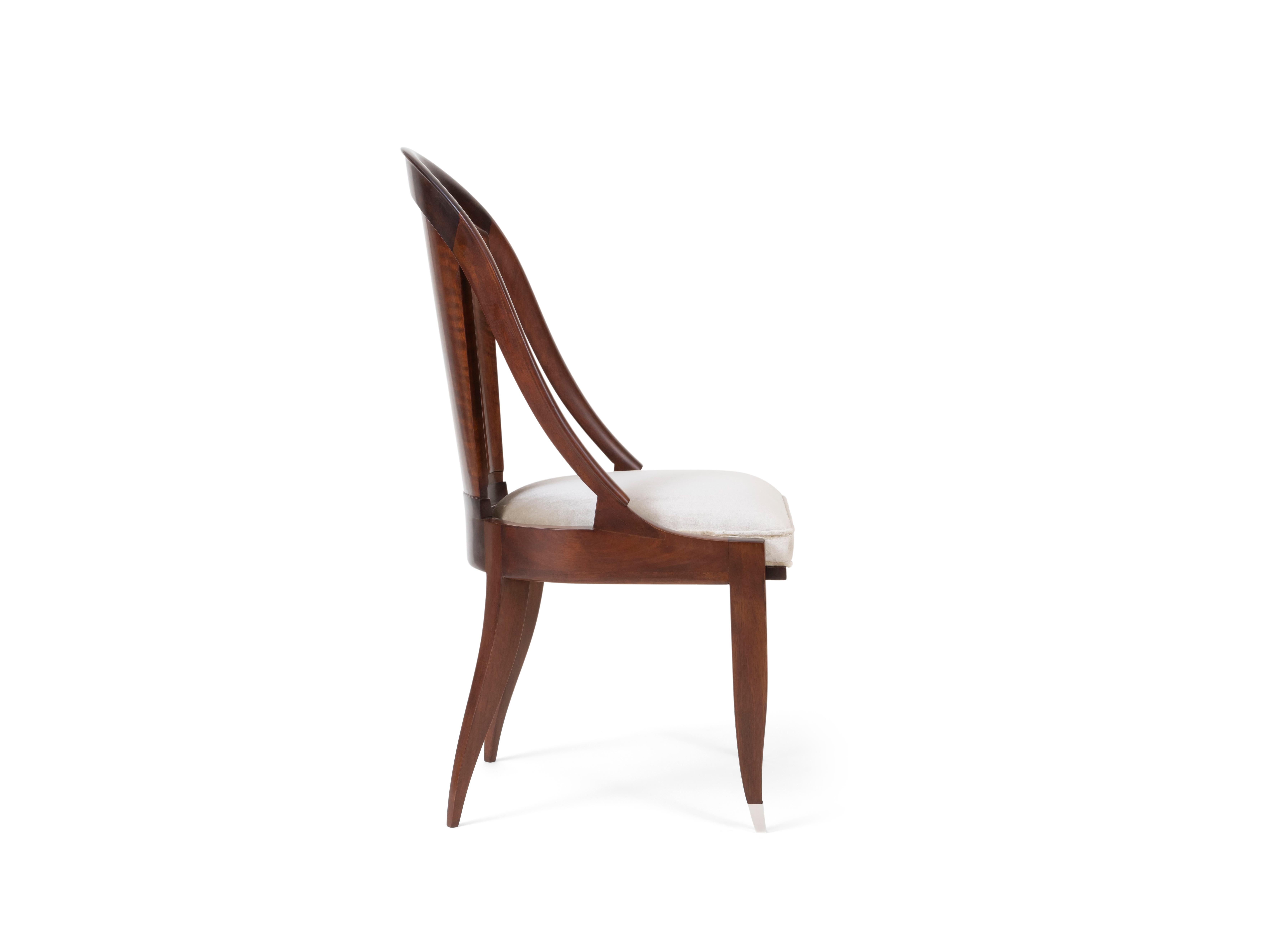 Mahogany ​'Cannelure' chair with sculpted gondola backrest over a white silk velvet seat raised on saber front legs capped with silver-plated sabots and curved rear legs. Stamped 