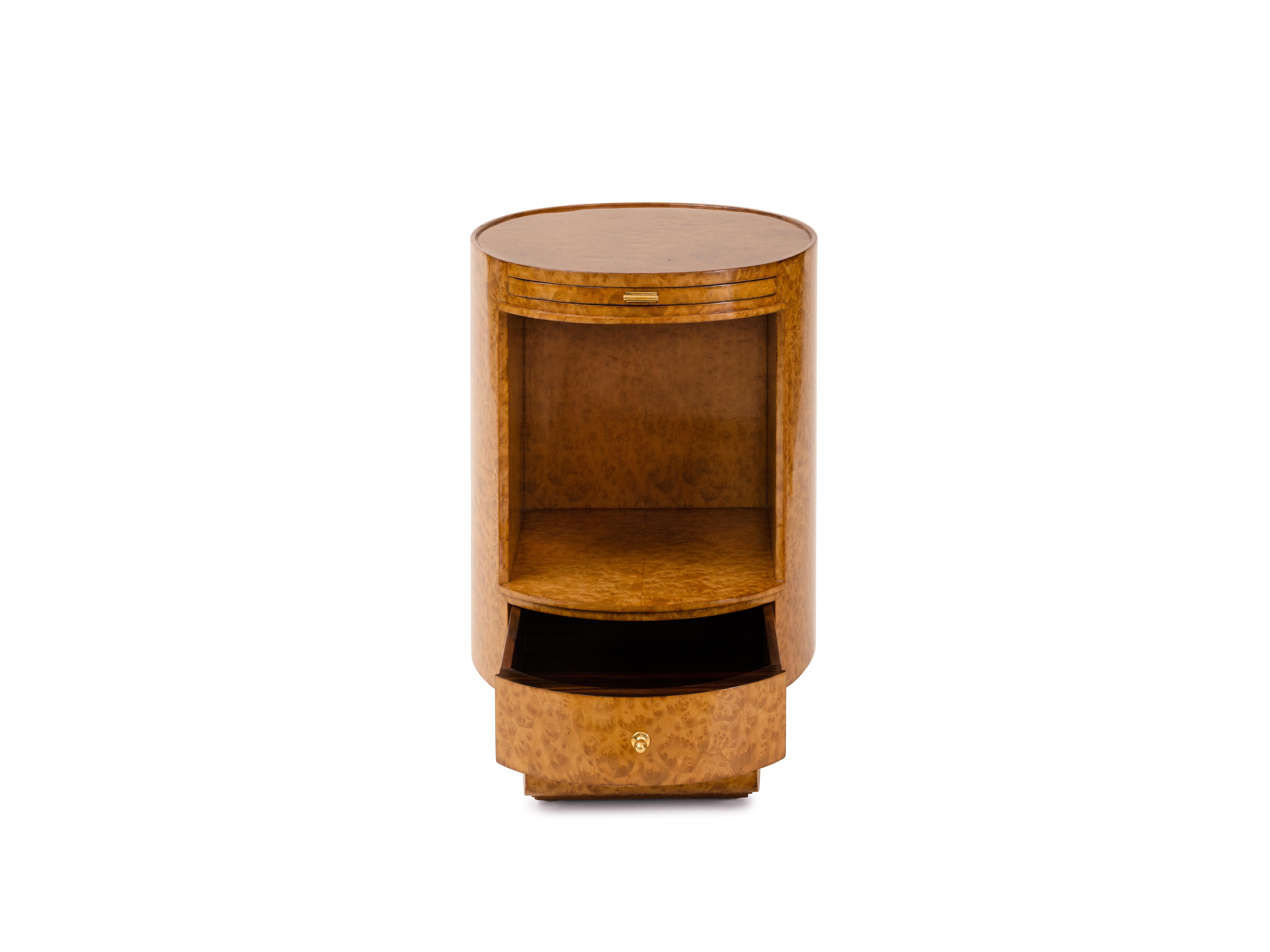 Exceptionnelle et rare table de chevet elliptique en placage d'Amboyna à œil d'oiseau. La table de nuit comporte une glissière à brosse et une boîte à tiroirs, chacune dotée d'une élégante quincaillerie, ainsi qu'un piètement à volutes. La pièce