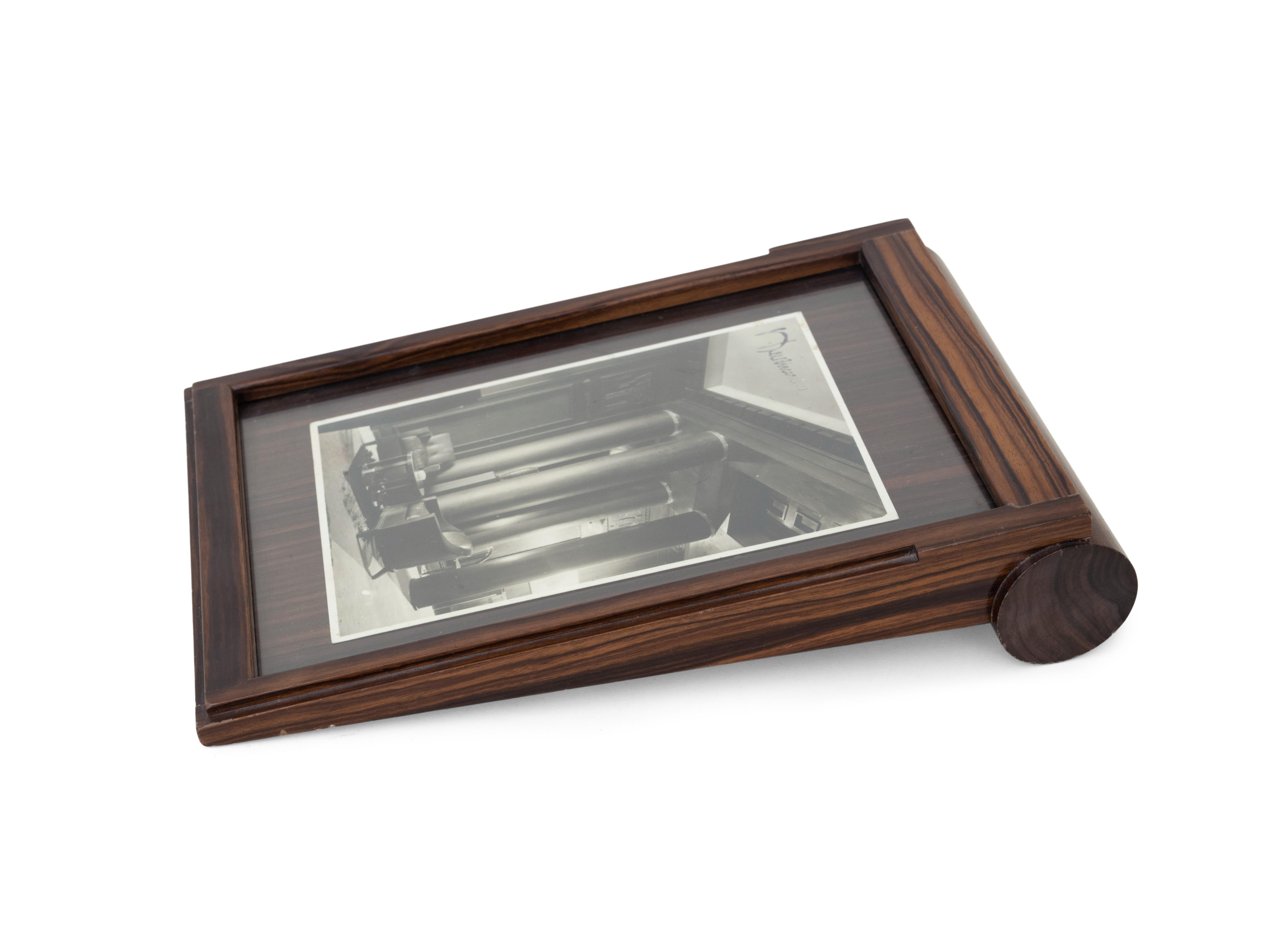 Photograph frame in Macassar ebony veneer and glass, bearing the mark of Atelier A. Referenced under nos. 3915AR and 1709NR in the Ruhlmann archives, Musée des Années 30, Boulogne. 

Émile-Jacques Ruhlmann (1879-1933) was a French furniture designer
