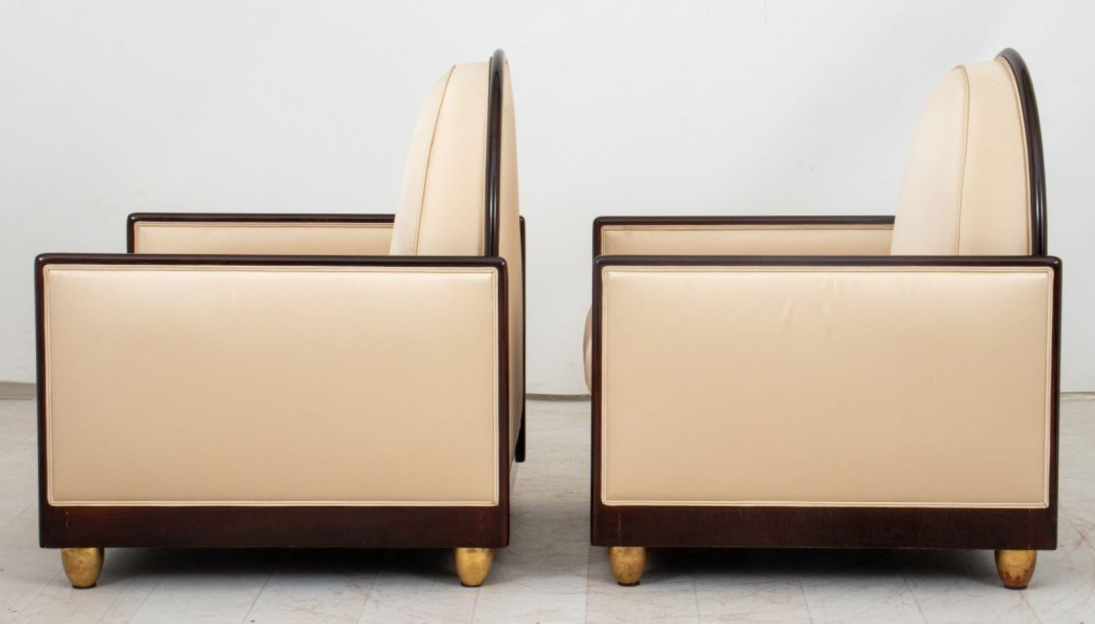 Pair of Art Deco wooden arm chairs in the style of Emile-Jacques Ruhlmann (French, 1879-1933), circa 1930s, the arched backs, cushions, and rectangular arms upholstered in a muted gold-tone silk, each upon four giltwood knob feet. 36