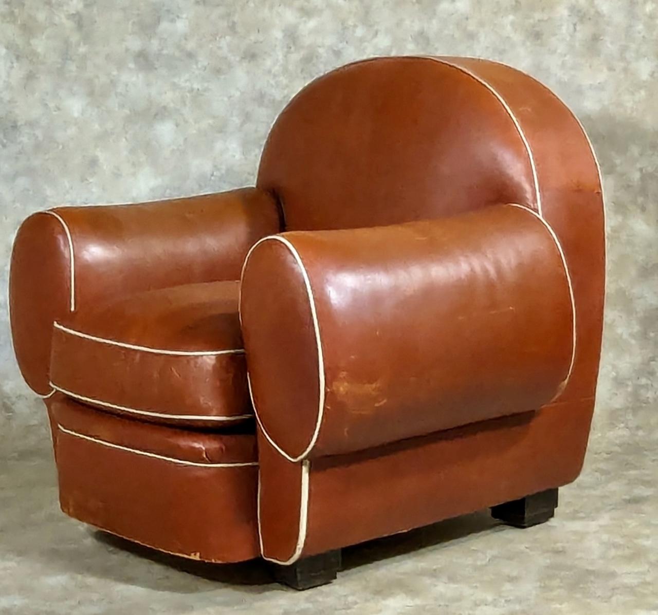 French Art Deco pair of club chairs by Ruhlmann, 1931, in leather with solid macassar ebony feet. One chair branded Designee Par Ruhlmann. 41” wide x  34” deep x 36” high. This model was presented at the  Paris Colonial Exposition in 1931. 

The
