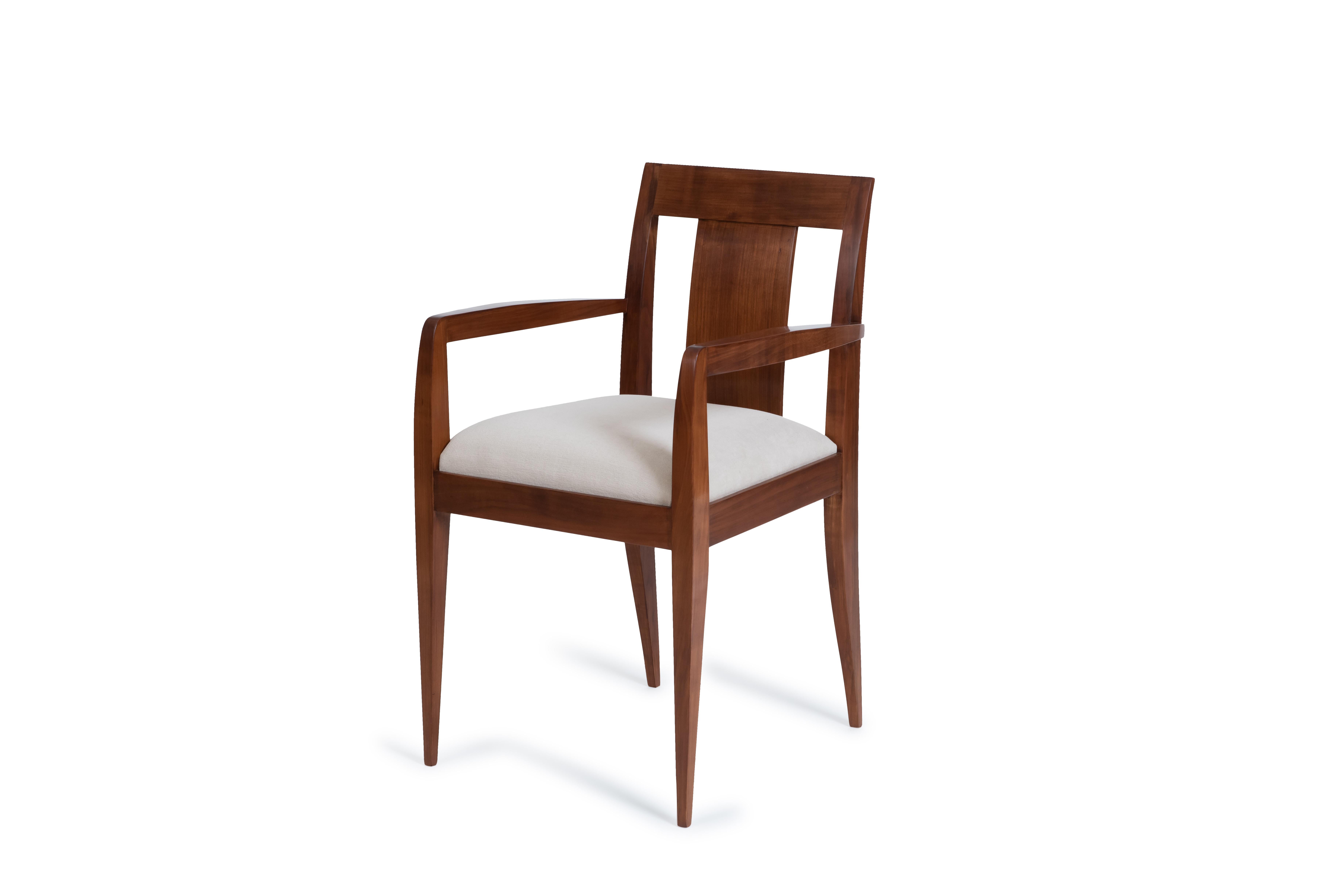 Pair of armchairs in polished walnut. The slightly arched back legs extend seamlessly into the open back frame, crafted from solid walnut. The front legs connect elegantly to the belt framing the seat.
This design is a variant of the model created