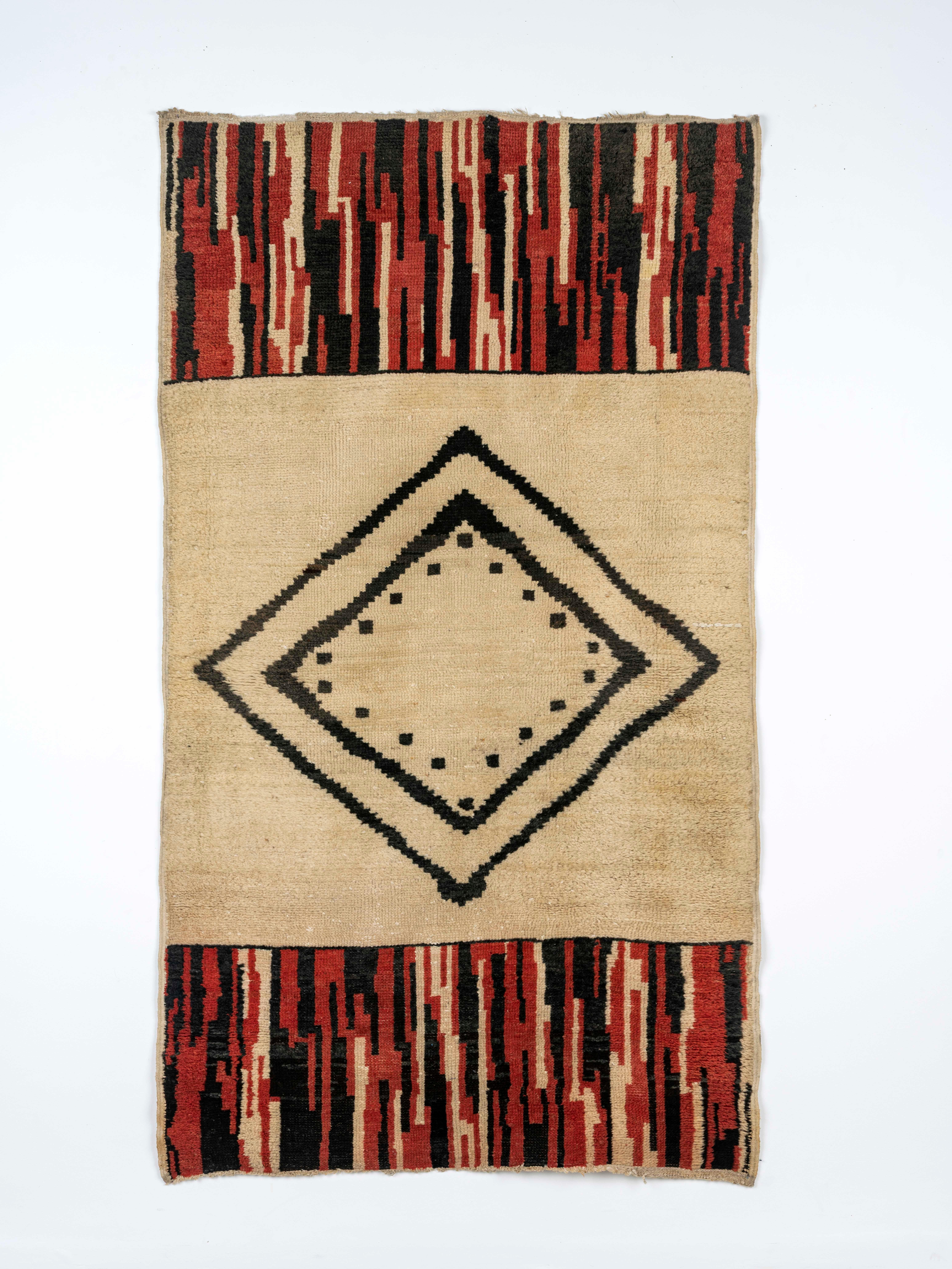 Alfombra rectangular de lana con un diseño geométrico rojo y negro sobre fondo beige.
Procedencia: Galería Crosta Smith, Londres  
 
Émile-Jacques Ruhlmann (1879-1933) fue un diseñador de muebles y decorador de interiores francés y una de las