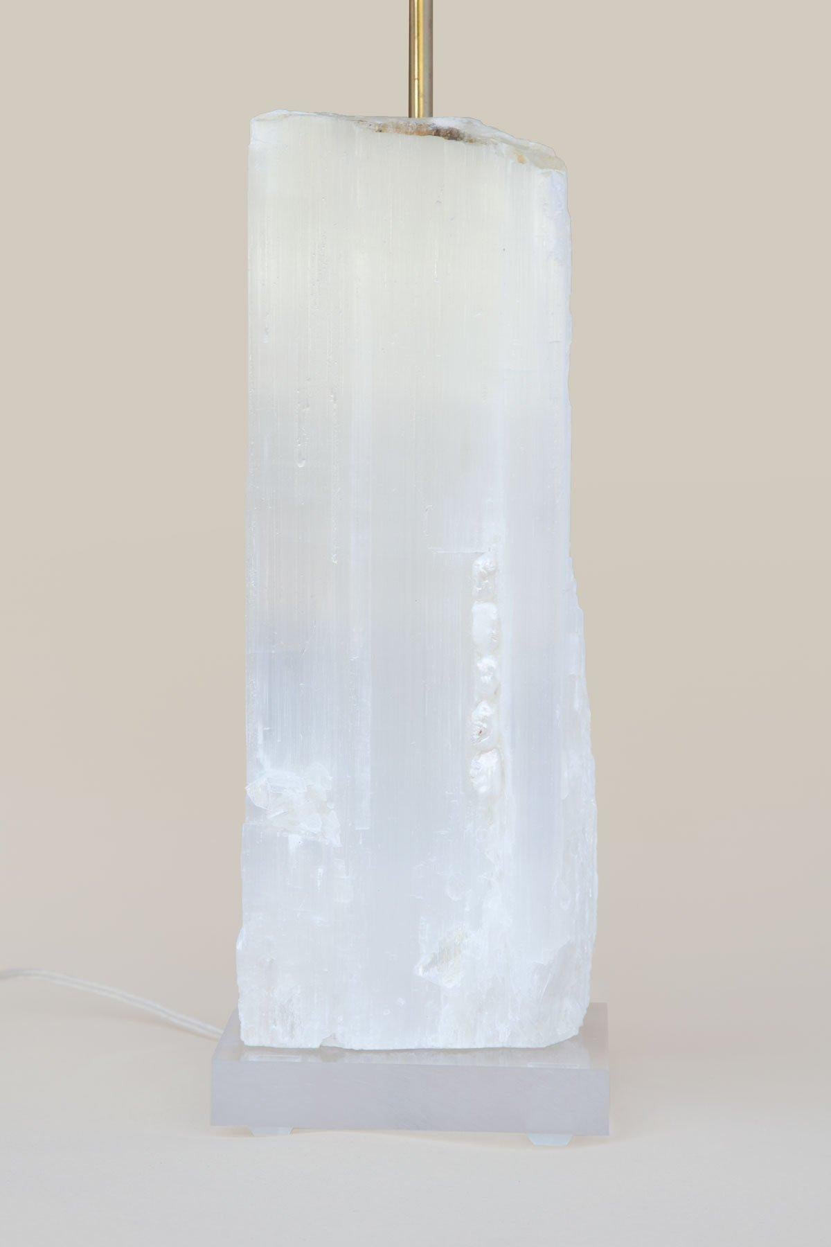 Une lampe de règle en sélénite avec des perles baroques sur de la lucite. 

La sélénite de Ruler est constituée de cristaux prismatiques uniques provenant du Maroc qui se sont formés dans des lits étendus par l'évaporation de saumure océanique. Ce