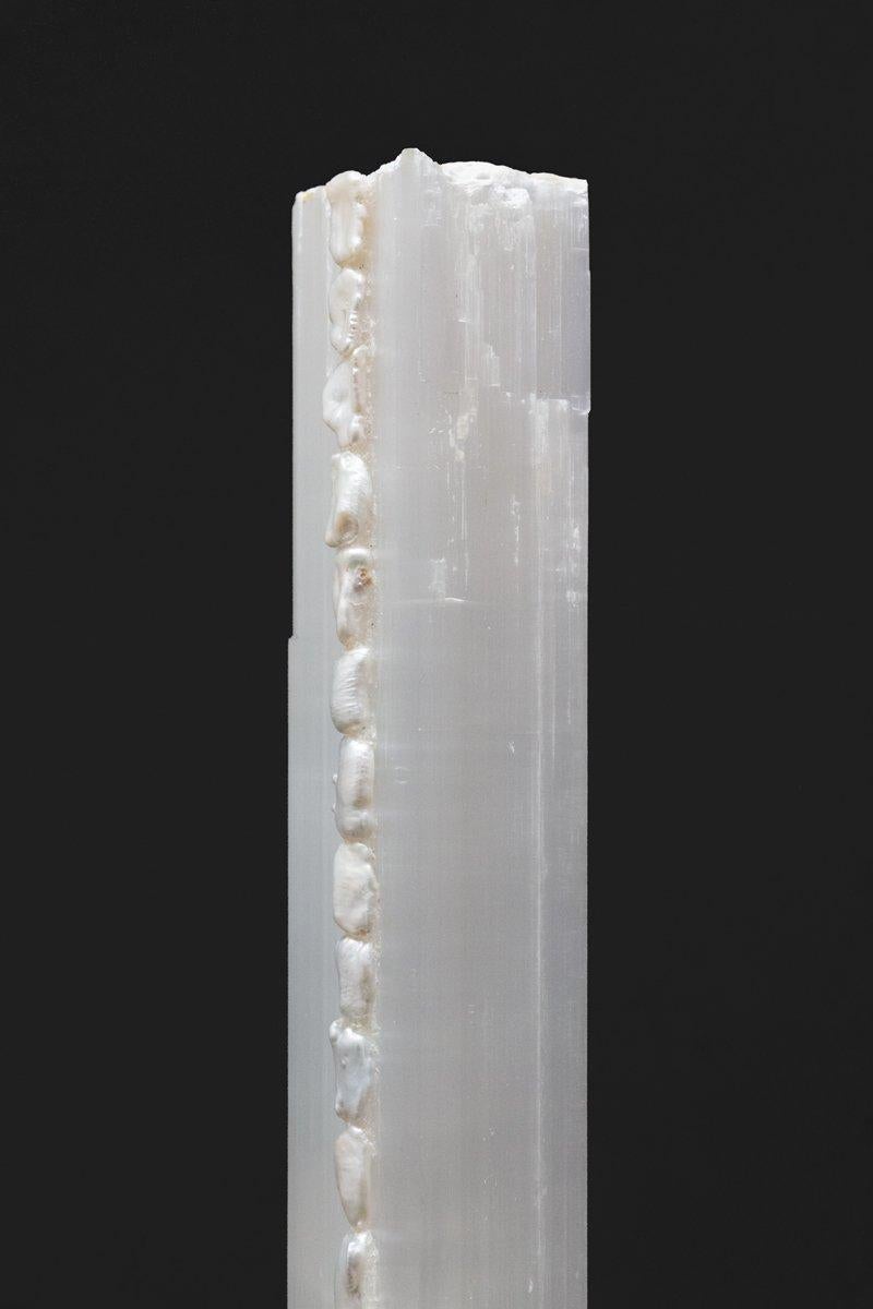 Ruler Selenite pillar with natural forming Baroque pearls on a Lucite base. Ruler Selenite is a single, prismatic crystal from Morocco that was formed in extensive beds by the evaporation of ocean brine. This mineral is characterized by a silk,