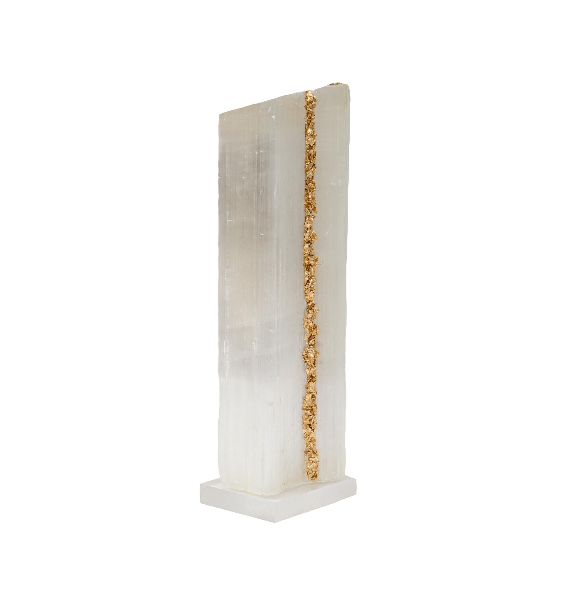 Ruler Selenite with gold leaf on a Lucite base. Selenite logs are single, prismatic selenite crystals from Morocco that were formed in extensive beds by the evaporation of ocean brine. This mineral is characterized by a silky, pearly luster called