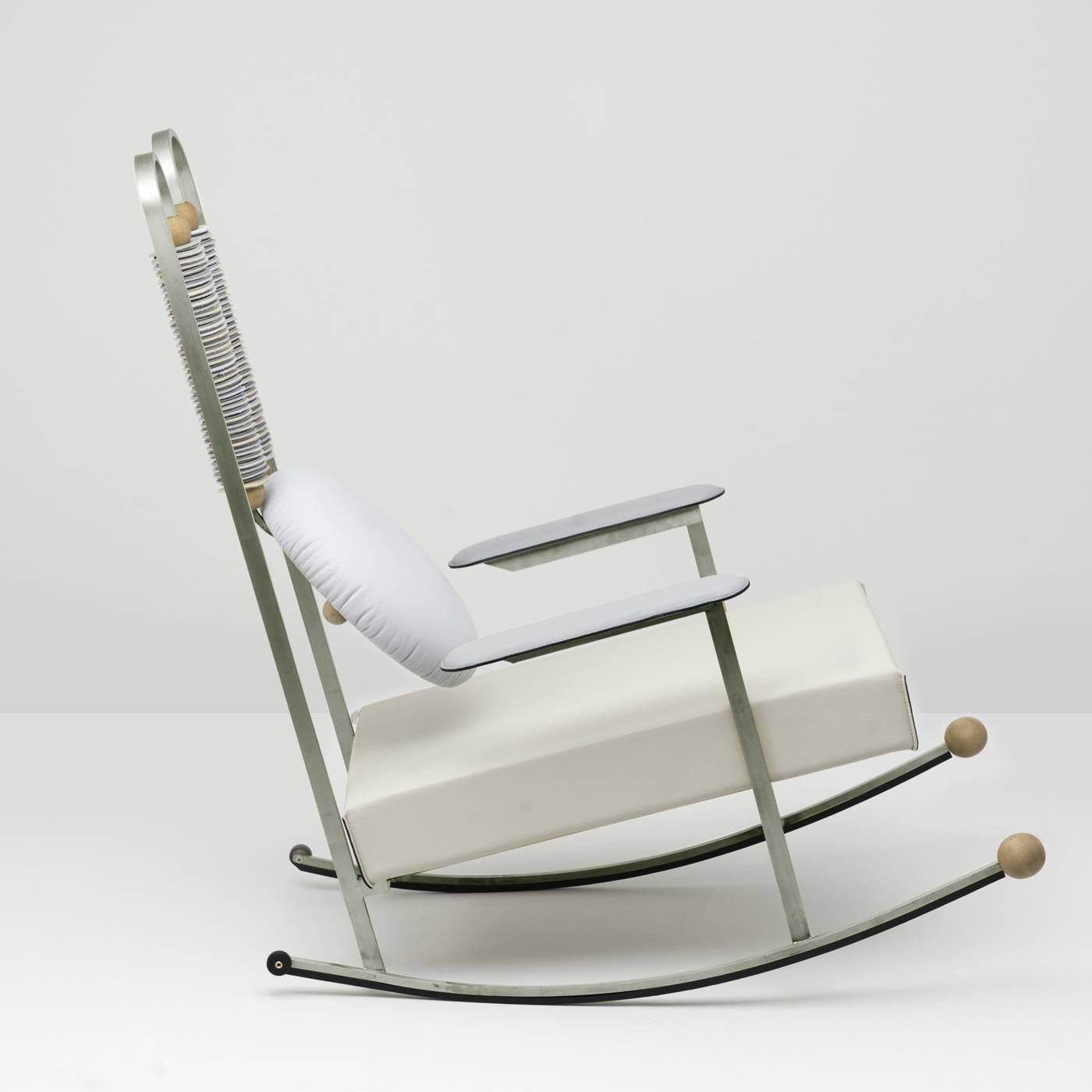 This striking rocking chair mixes different textures for a unique effect. Its structure is in iron and steel with a protective finish, while the cushions for the seat, backrest and armrests in polyurethane foam are hand-upholstered with natural