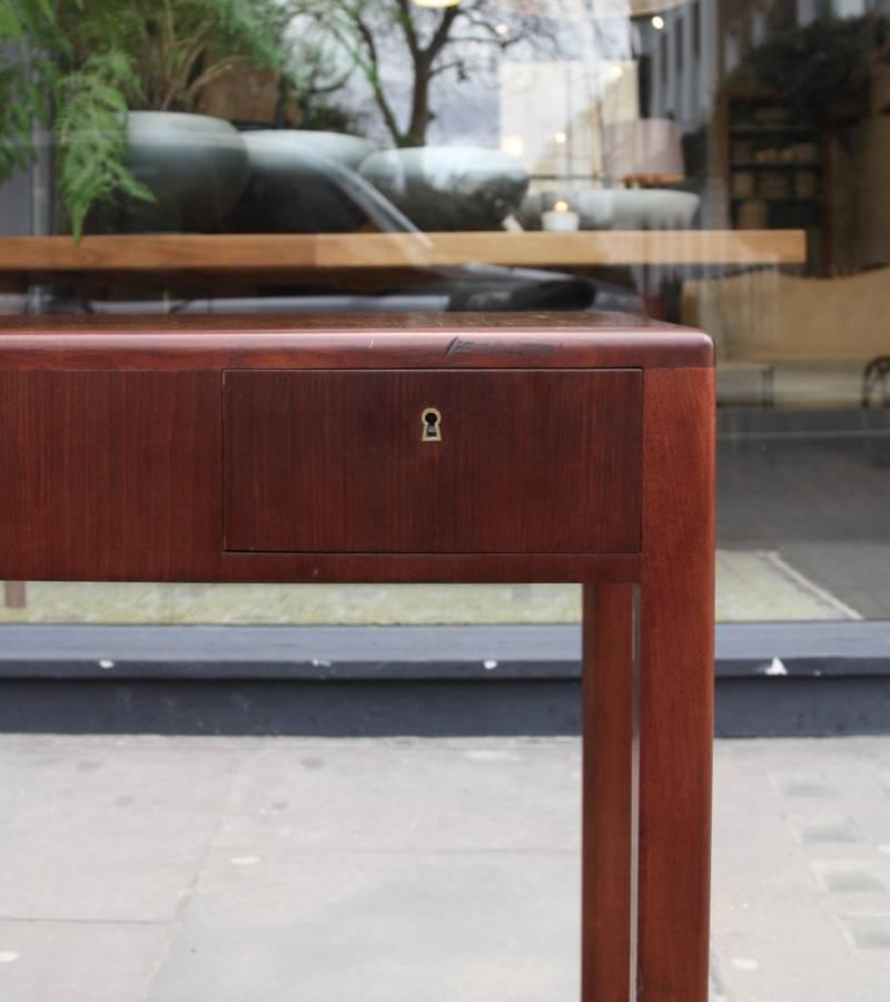 A vintage little desk by Rud Rasmussen, Denmark, 1930s.
Made in solid mahogany and veneered in the same timber, the desk has two small drawers with brass keyholes. The drawers are made in oak, while the front is in mahogany; sides and front of the