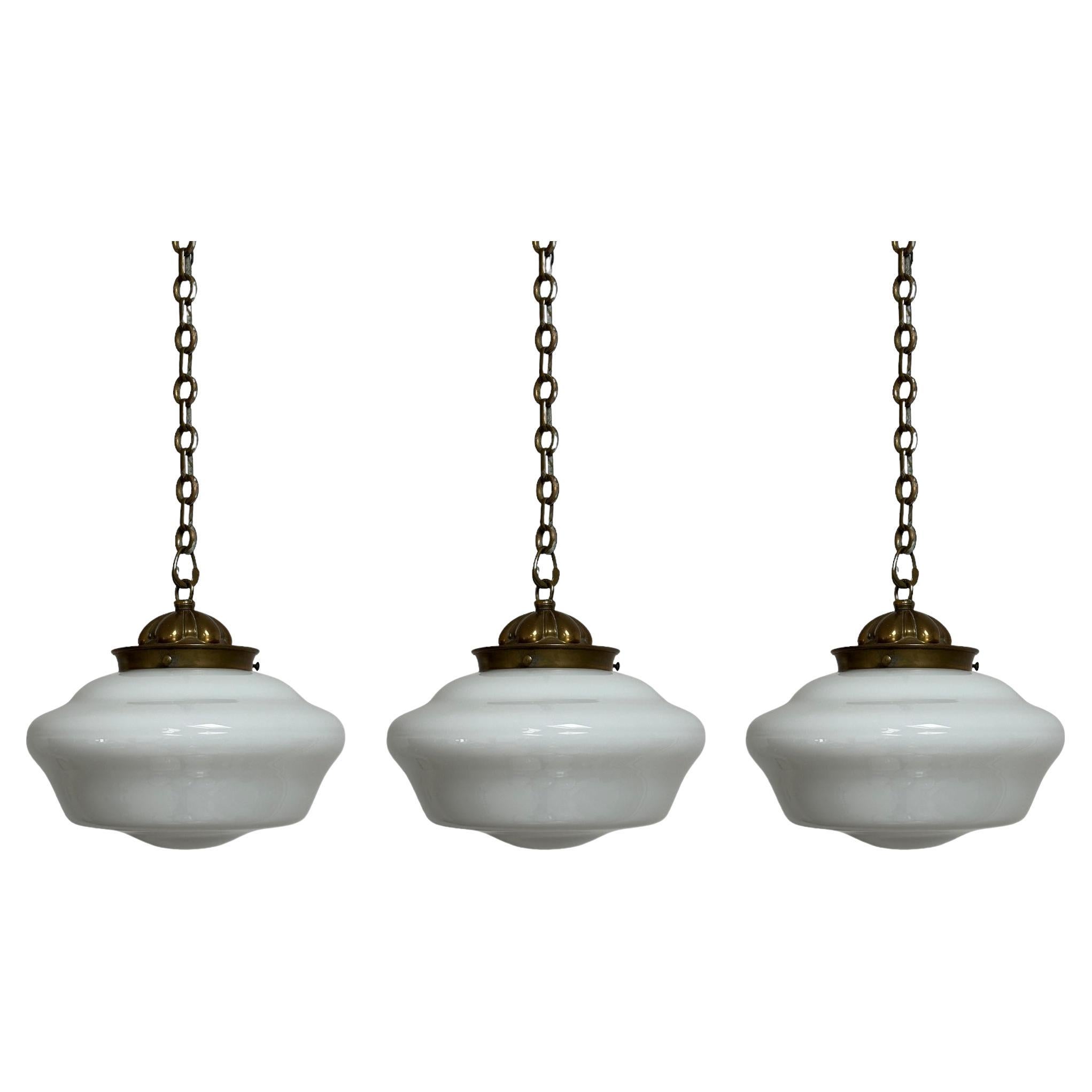 - A rare and impressive run of 'Hailware' opaline brass ceiling pendants by Hailwood & Ackroyd, England circa 1930. 
- This large run of milk glass pendant lights originally hung inside an old Cambridge University in England and are in a wonderful