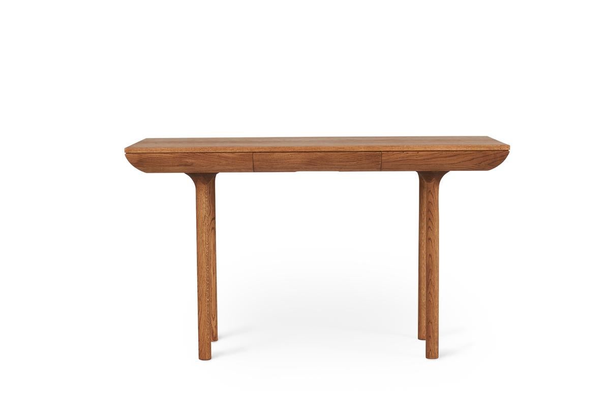 Rúna teak oiled oak desk by Warm Nordic
Dimensions: D130 x W65 x H74 cm
Material: Teak oiled solid oak
Weight: 37 kg
Also available in different finishes. 

Timeless desk with a poetic idiom and a neat little drawer. With its pure and classic